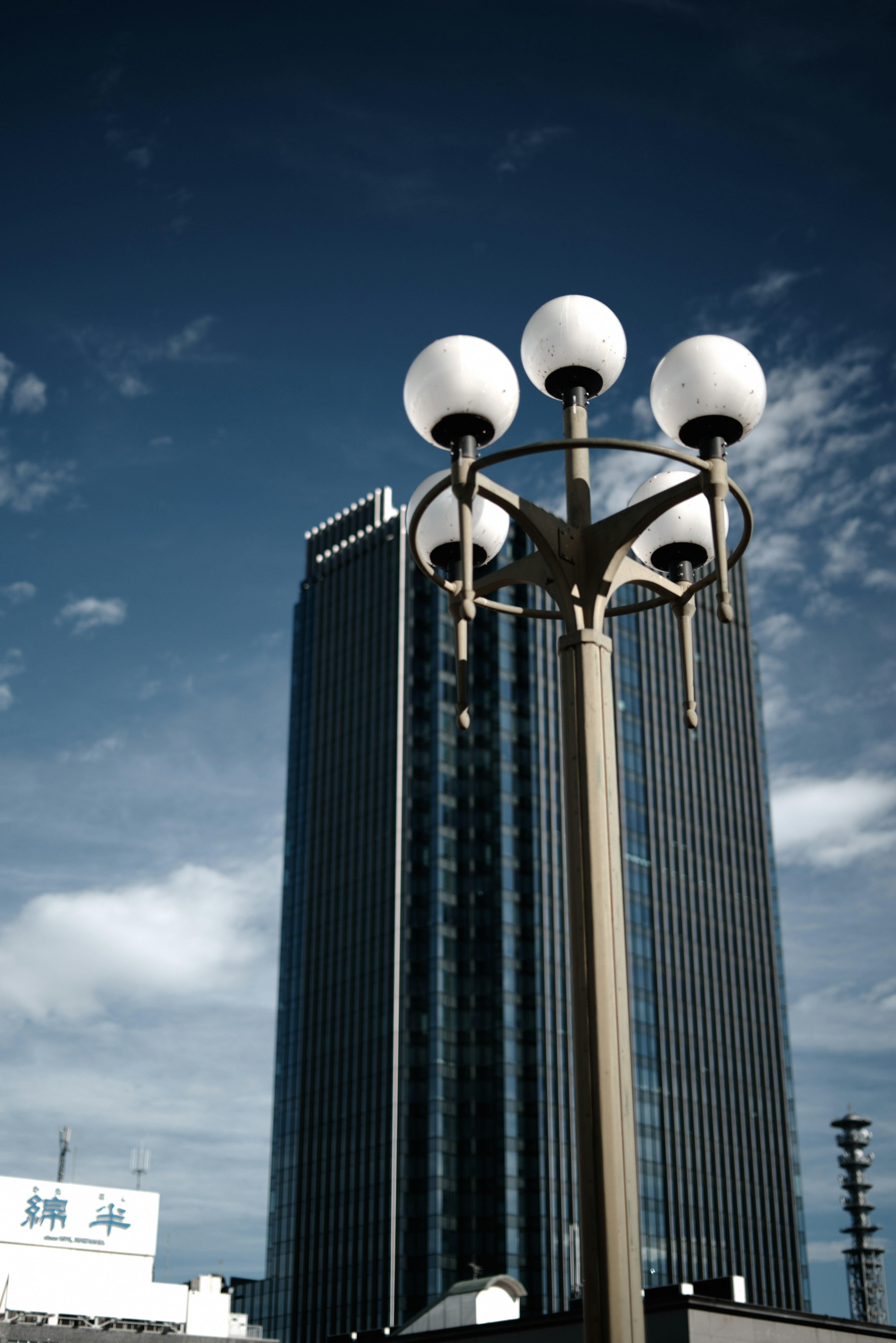 Cityscape featuring a tall building and a modern street lamp