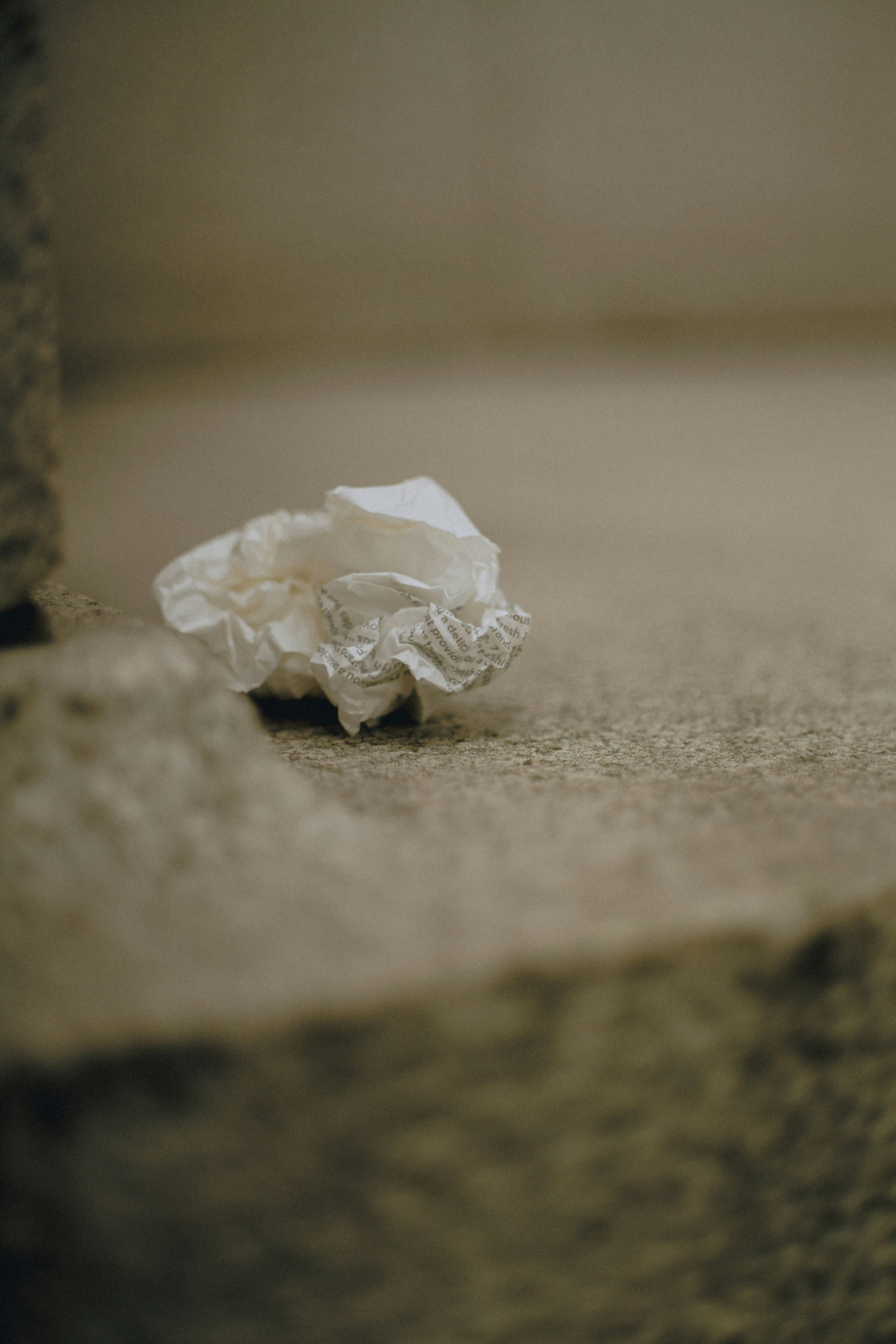 Un papier froissé blanc sur une surface en pierre