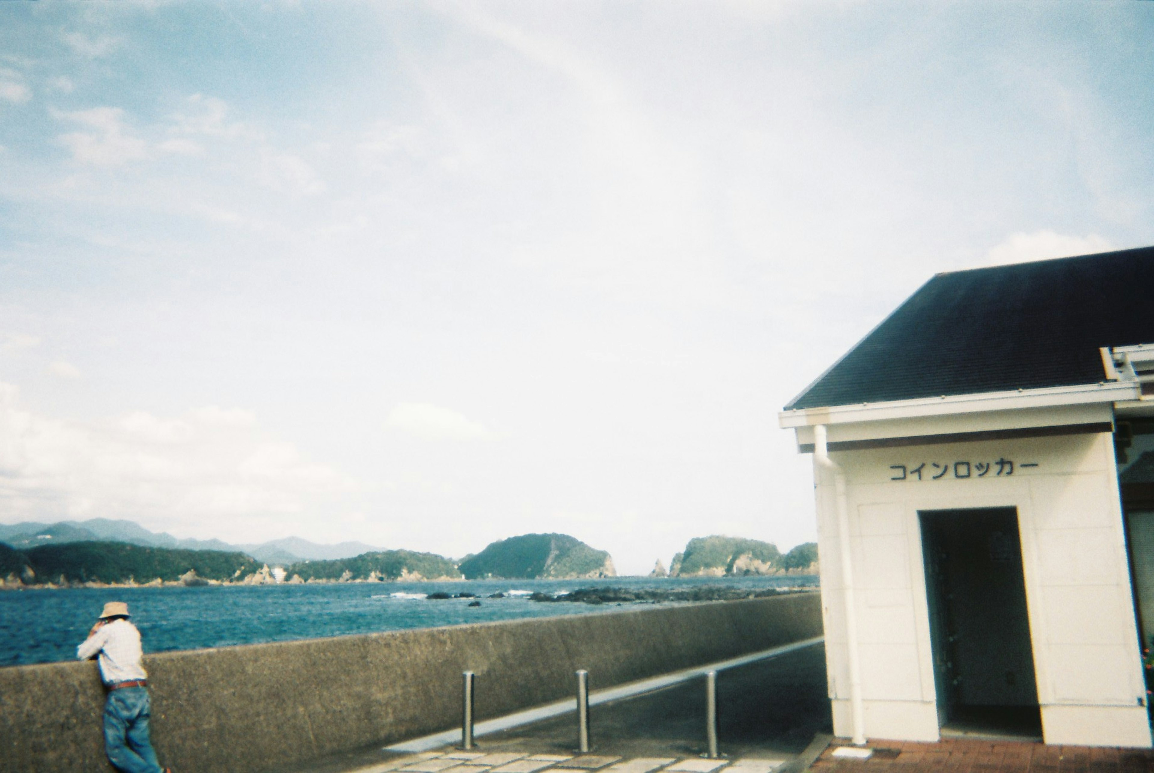 Personne regardant la mer à côté d'un bâtiment blanc