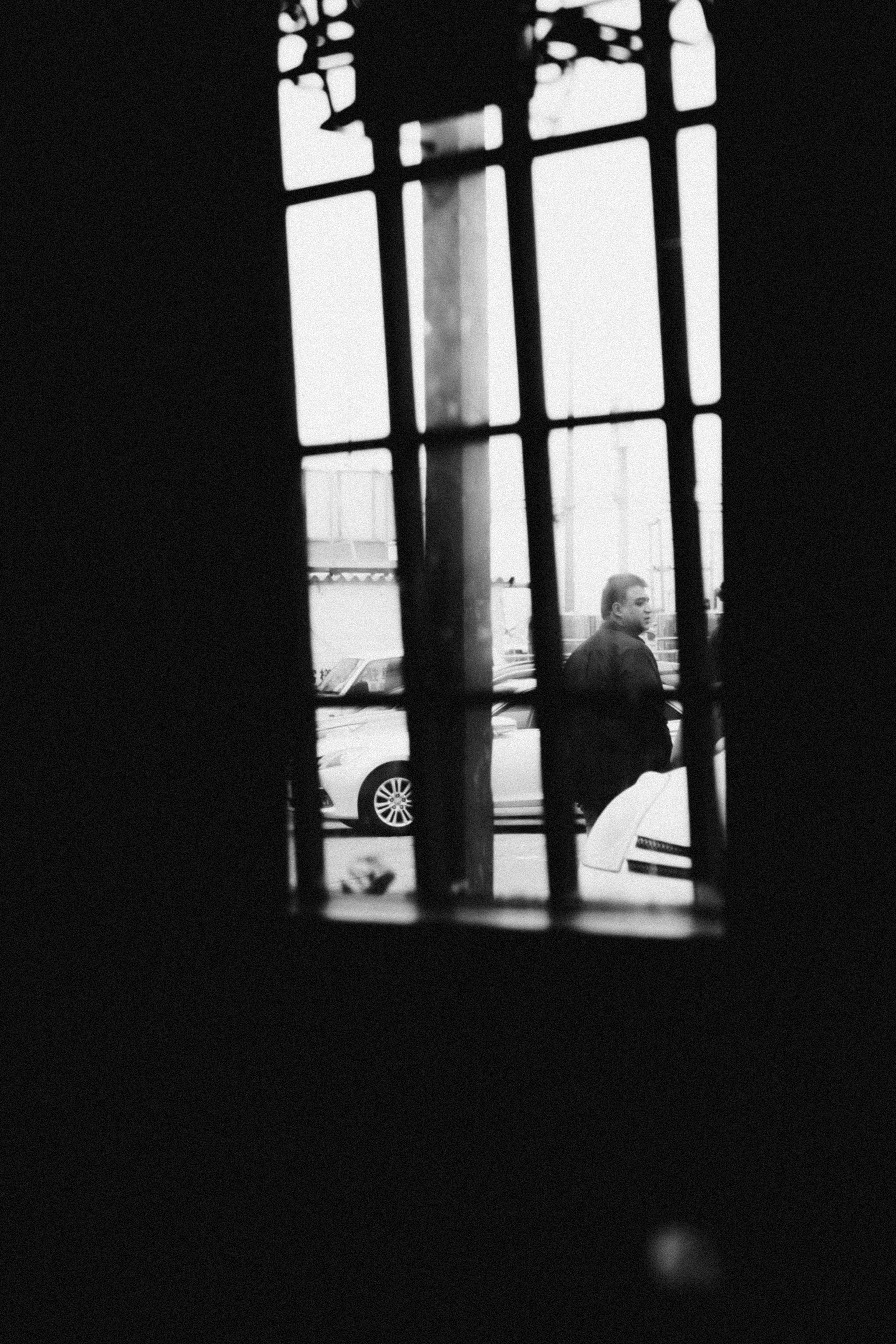 Vista en blanco y negro de una persona a través de una ventana