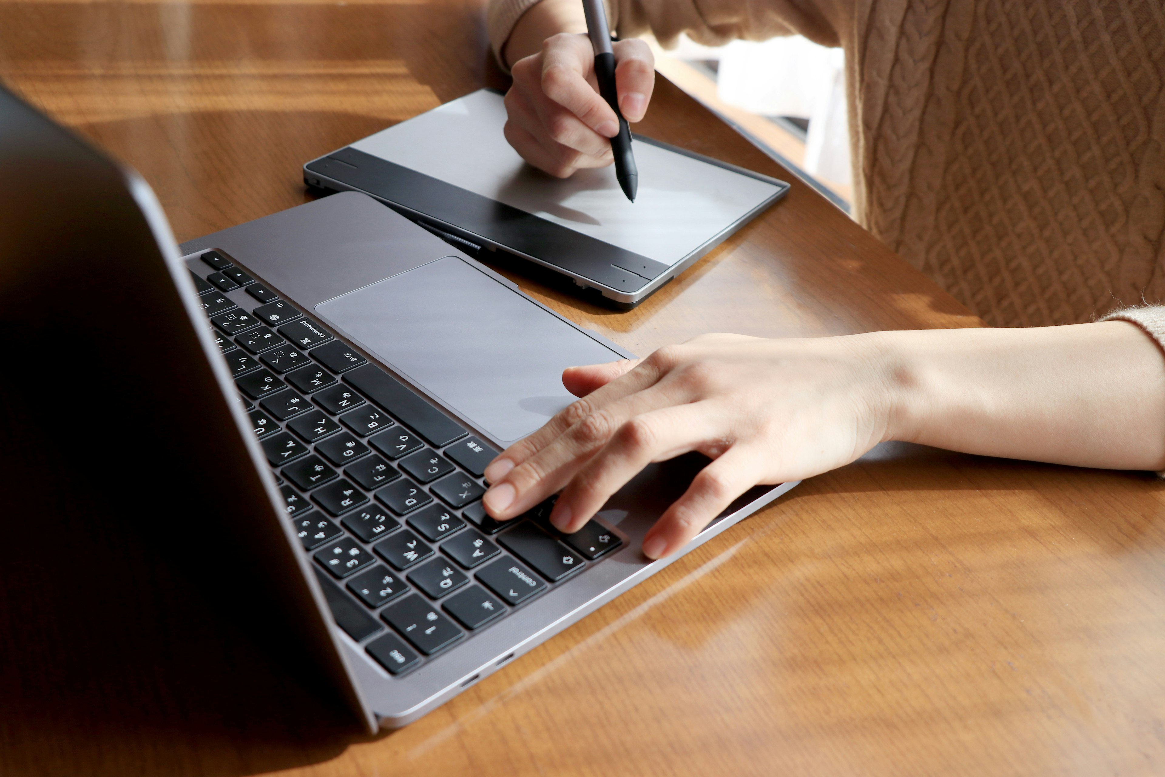 Primo piano delle mani che usano un laptop e un tablet