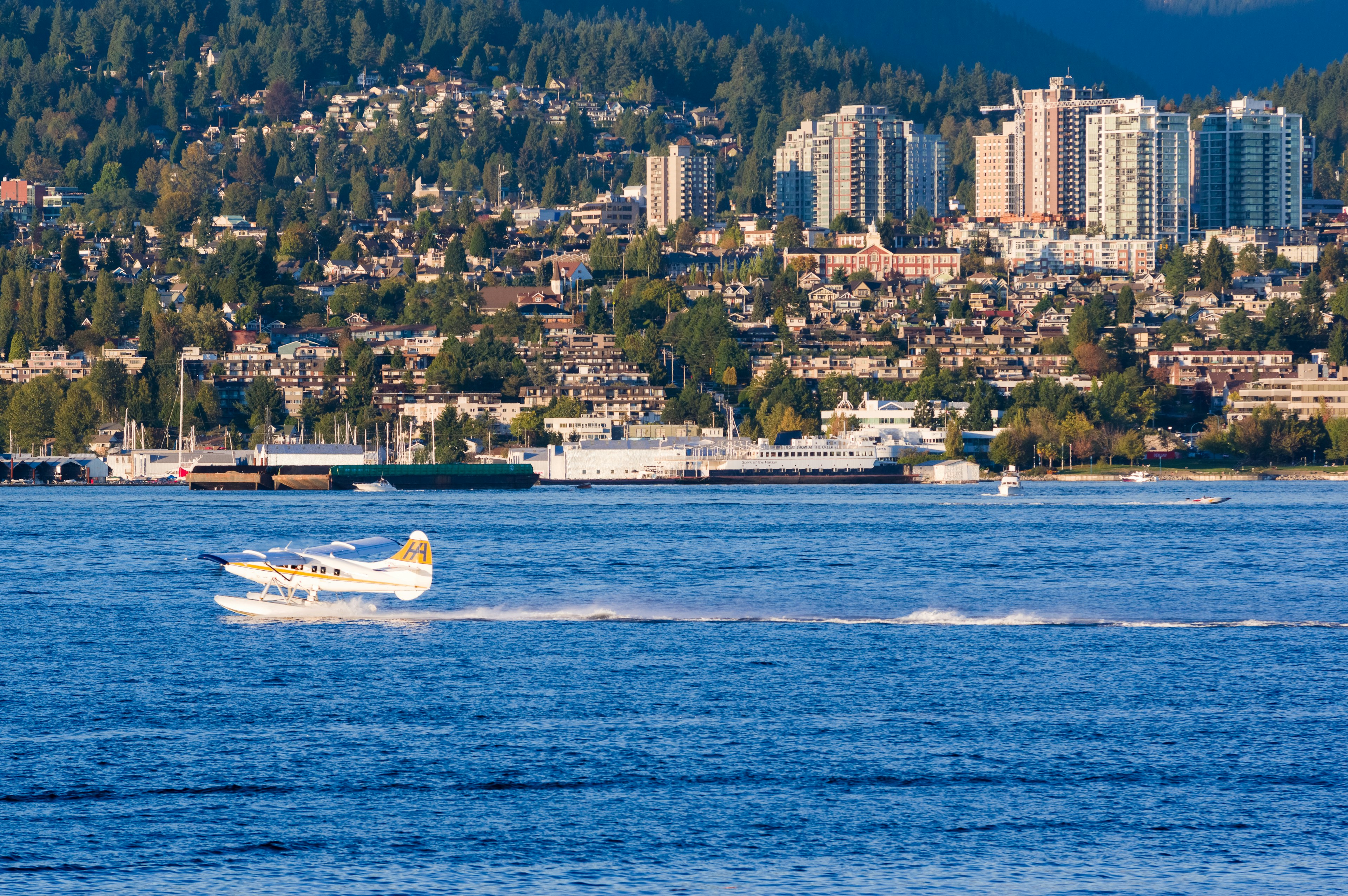 Hydravion survolant l'eau avec la ville en arrière-plan