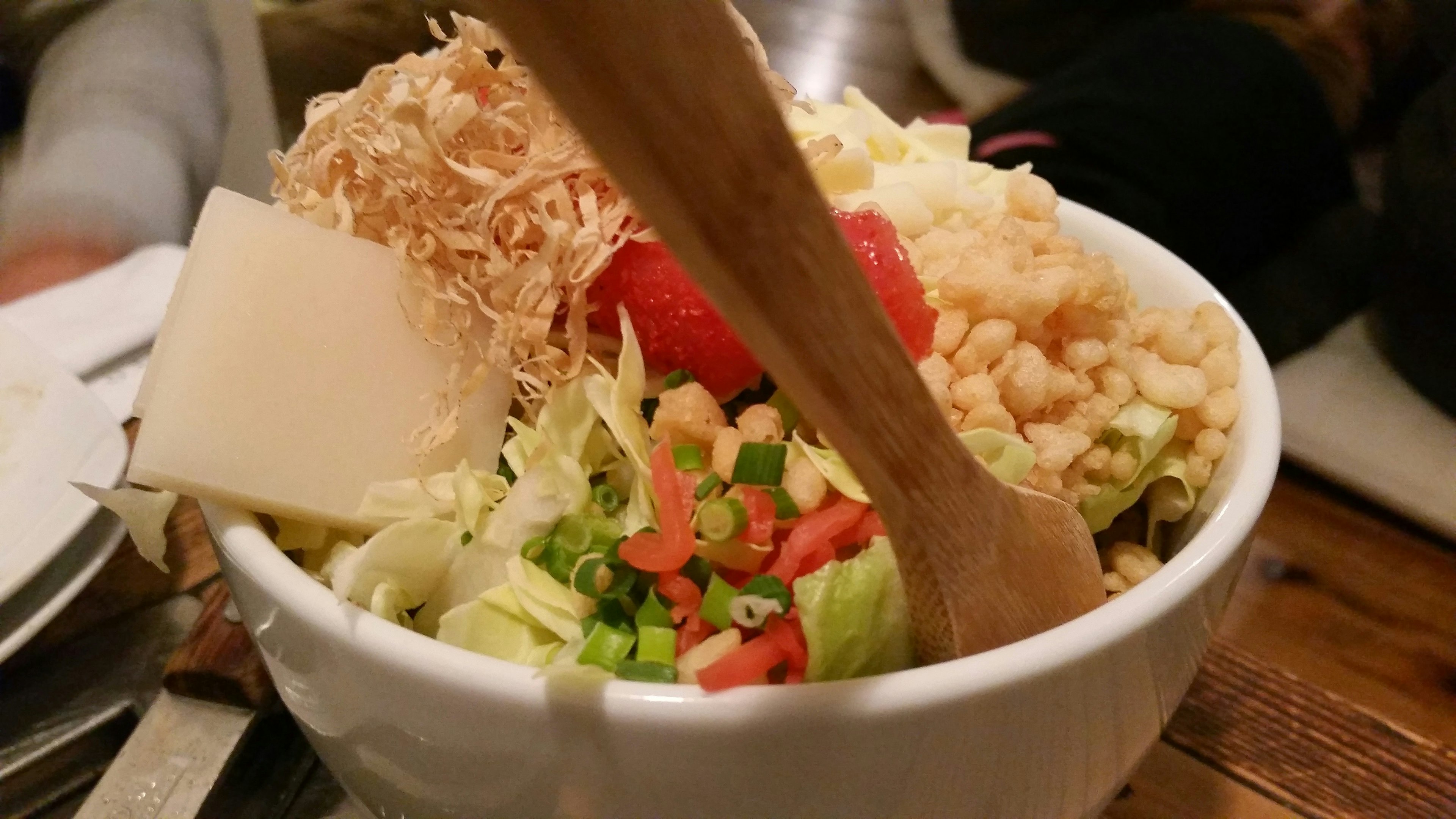 A bowl filled with fresh salad and various toppings