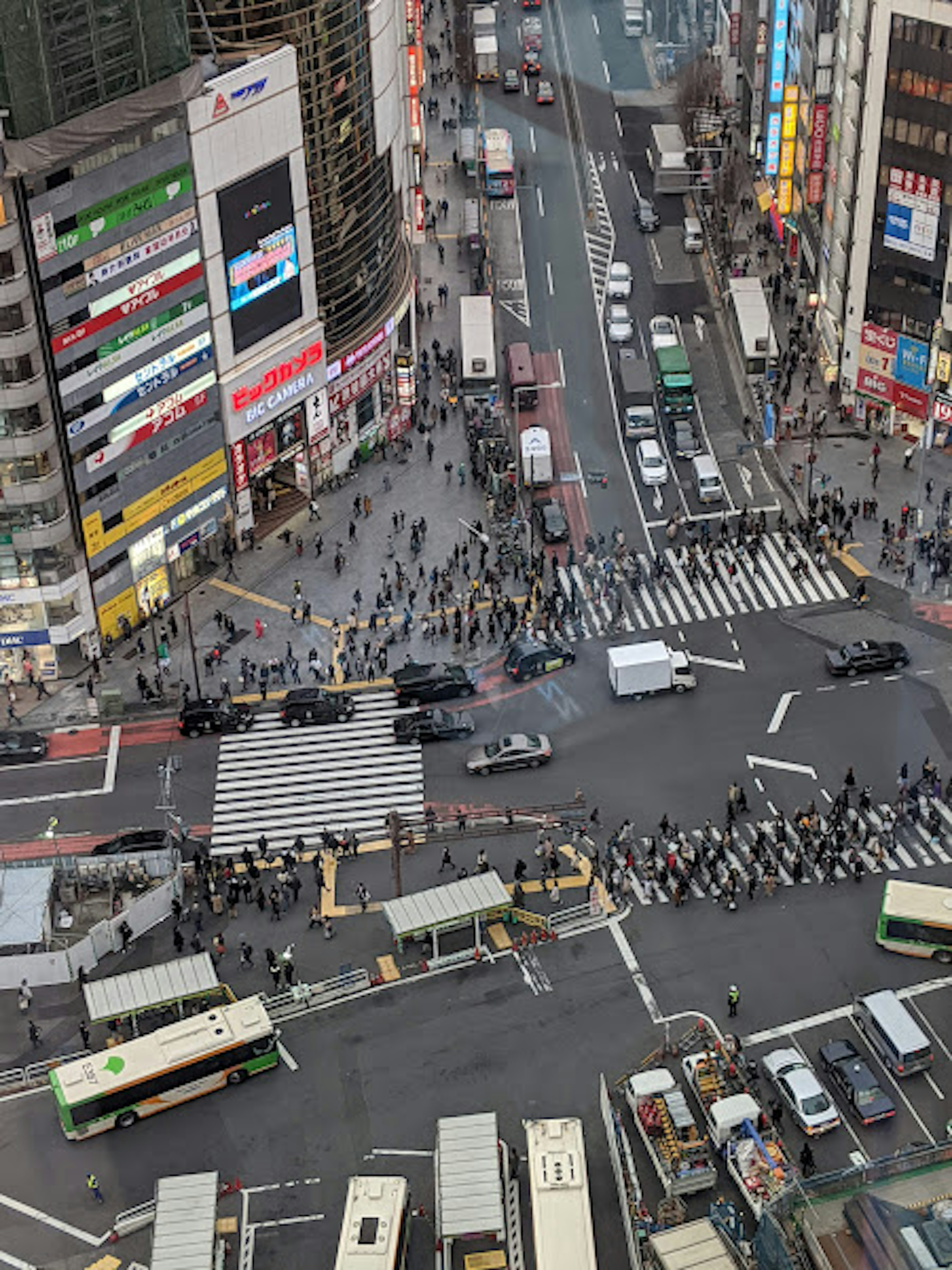 Luftaufnahme der Shibuya-Kreuzung mit zahlreichen Fußgängern und starkem Verkehr in einer städtischen Umgebung