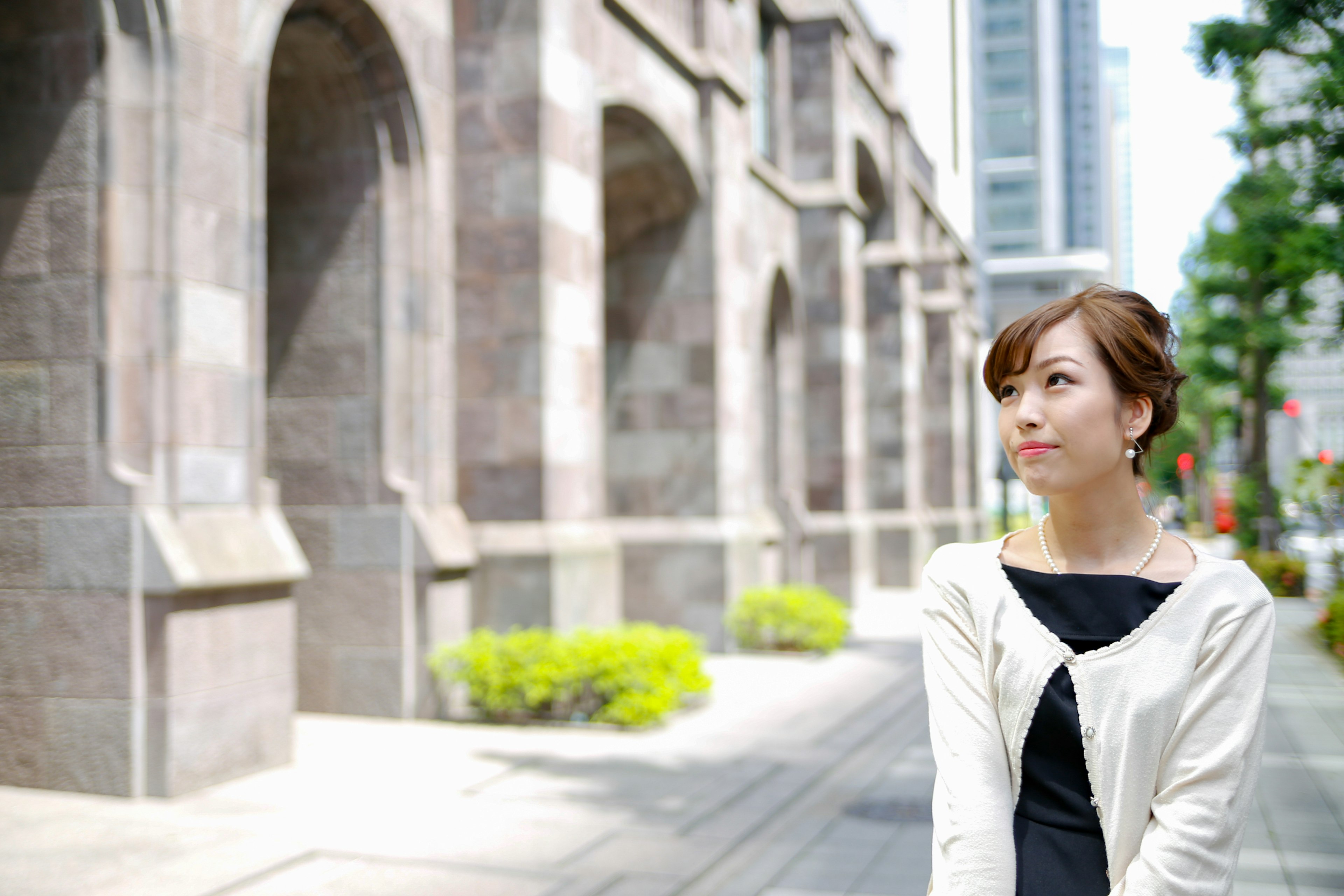 Portrait of a woman against an urban backdrop featuring modern buildings and historical architecture