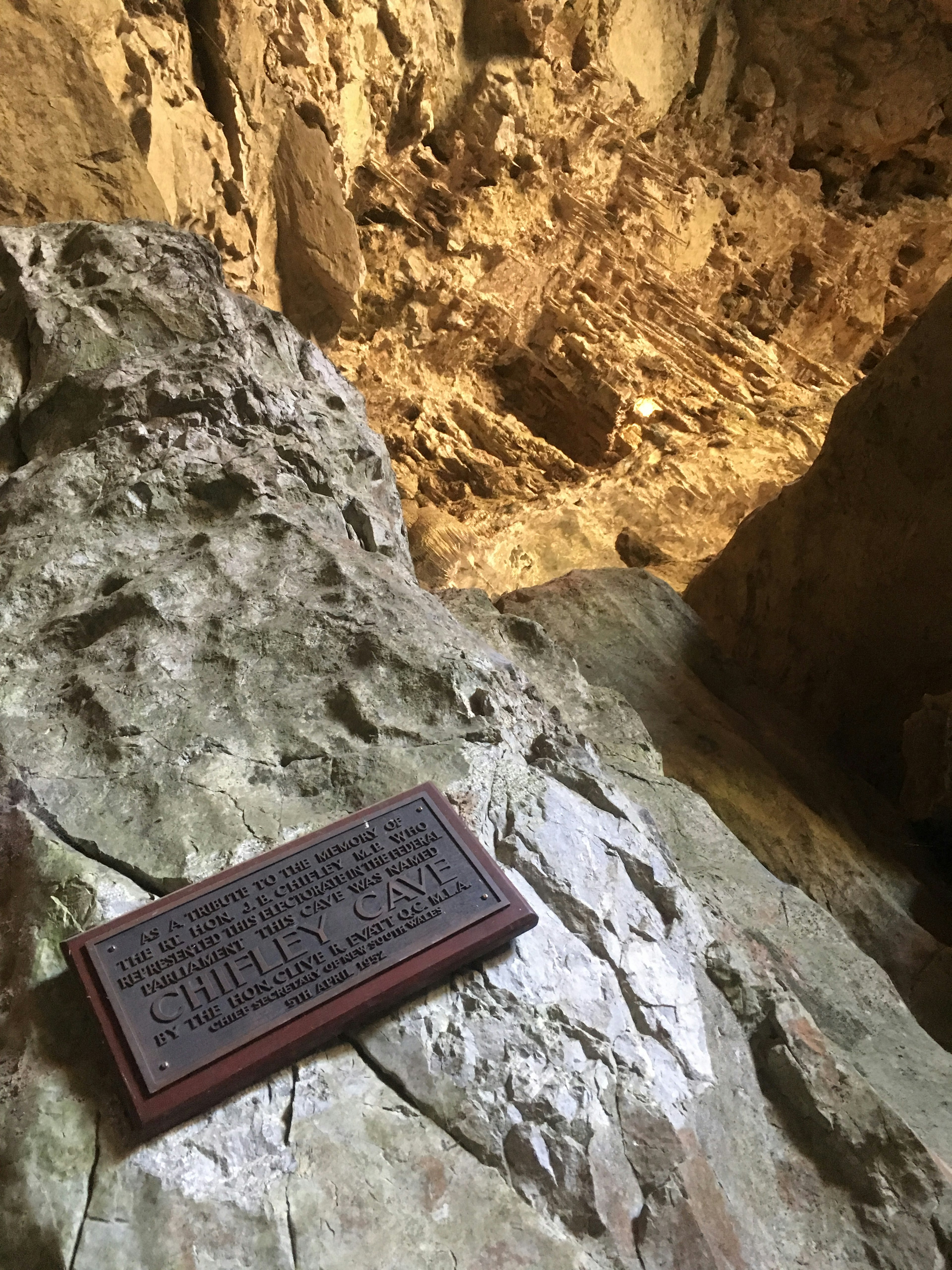 Close-up of cave rocks with a descriptive plaque