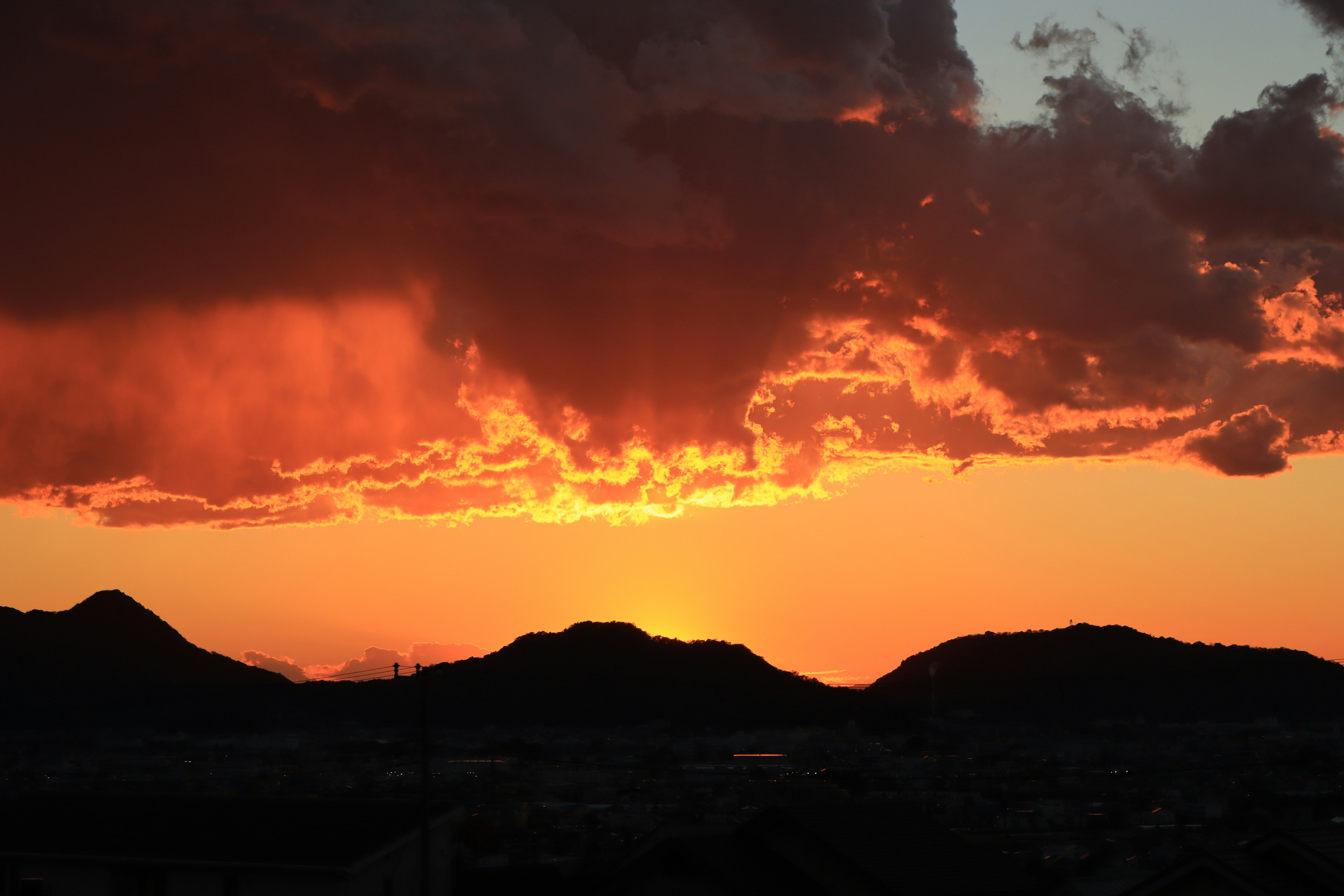 Wunderschöne Sonnenuntergangslandschaft mit silhouettierten Bergen