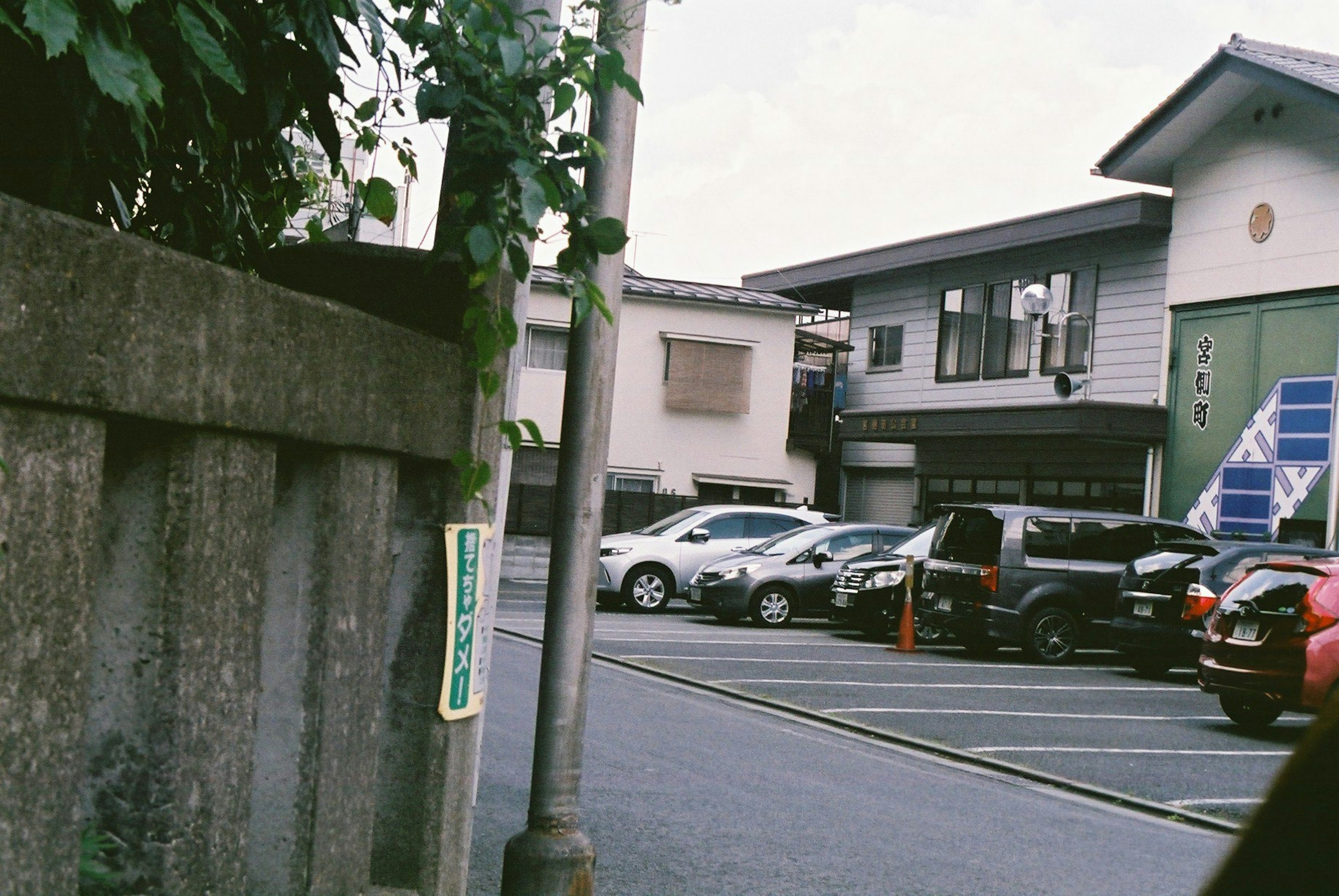 住宅街の駐車場に並ぶ車と建物の風景