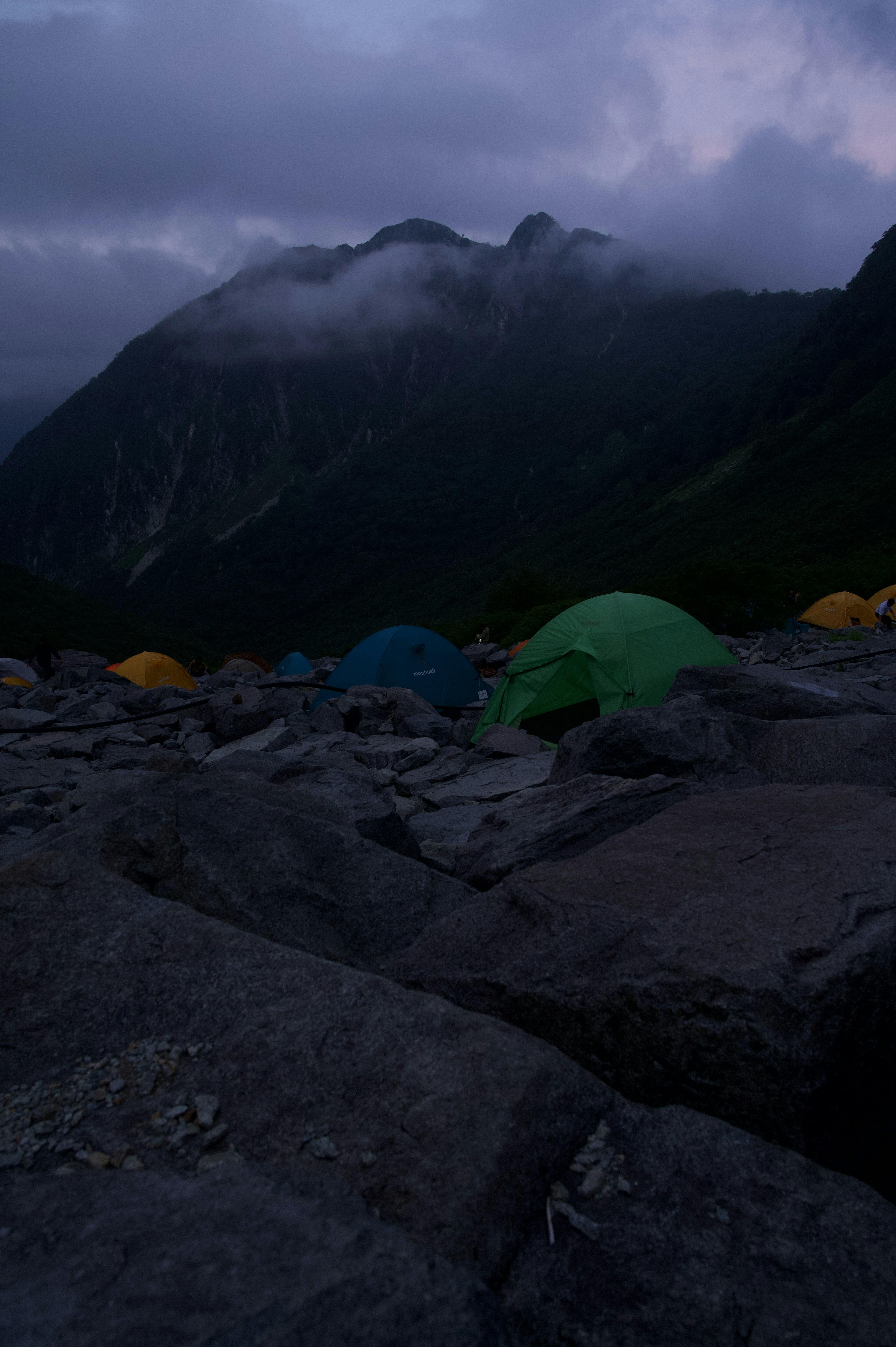 Nachtcamping-Szene mit bunten Zelten und Bergen