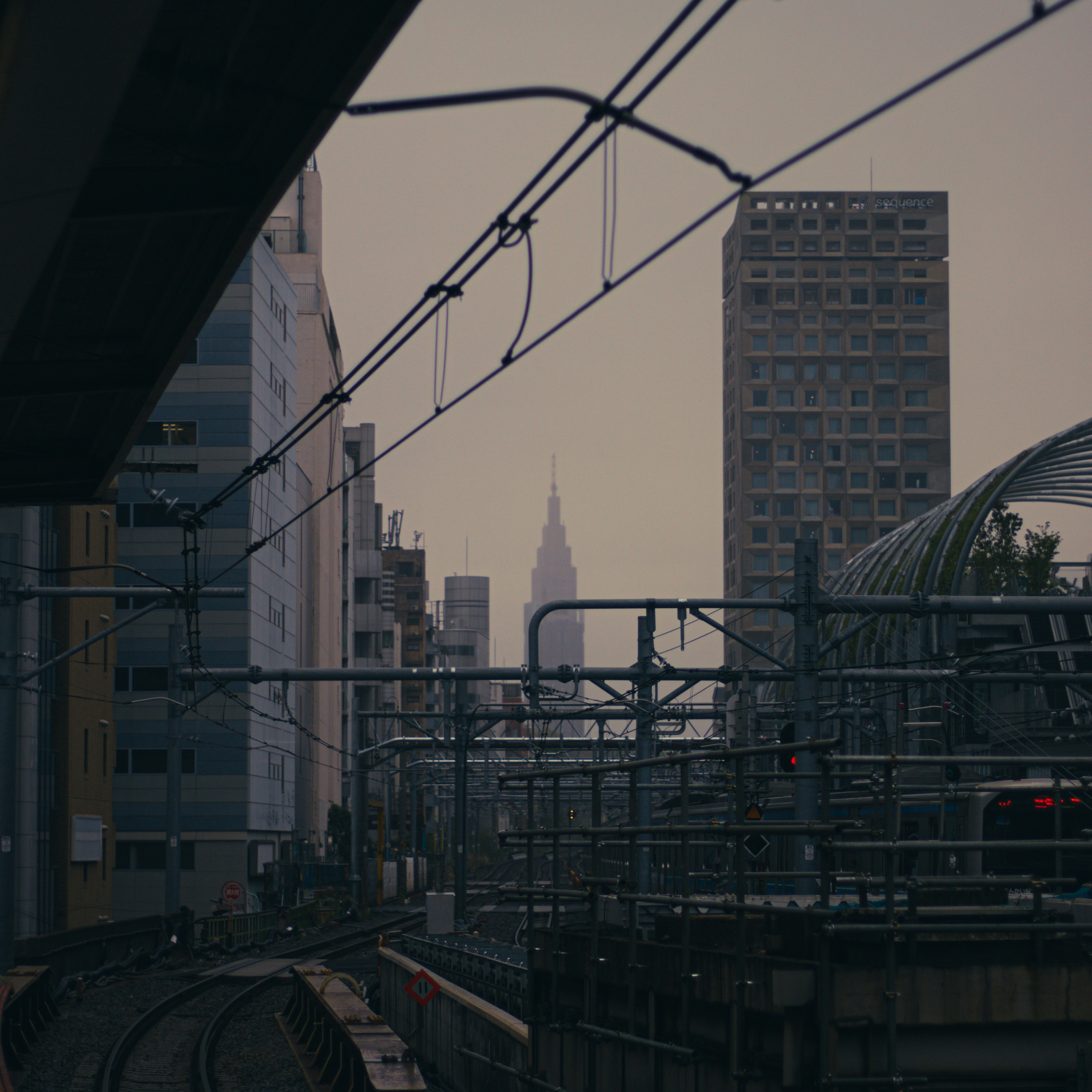 Urban landscape featuring railway tracks with skyscrapers and the Empire State Building in the background