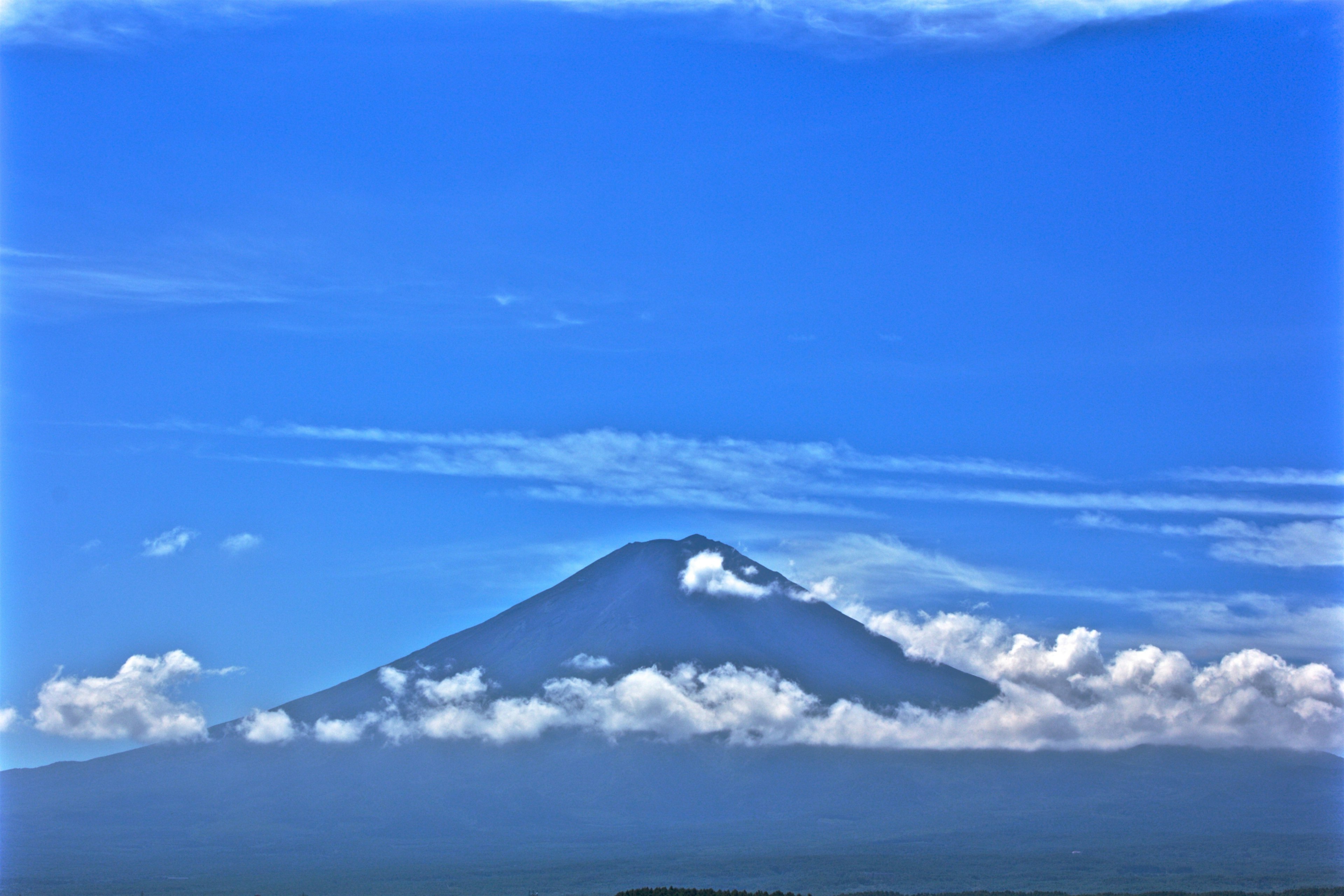 Mont Fuji se dressant sous un ciel bleu avec un sommet couvert de nuages