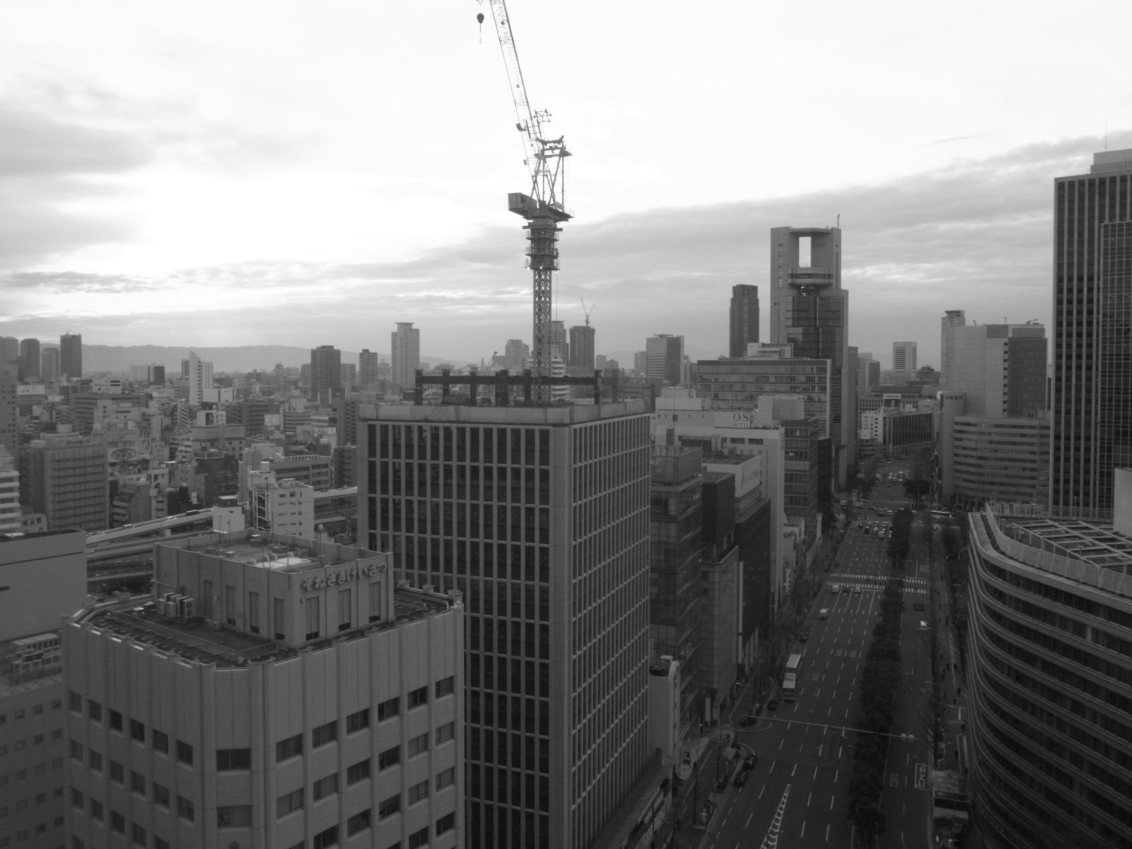 Black and white cityscape featuring high-rise buildings and a crane