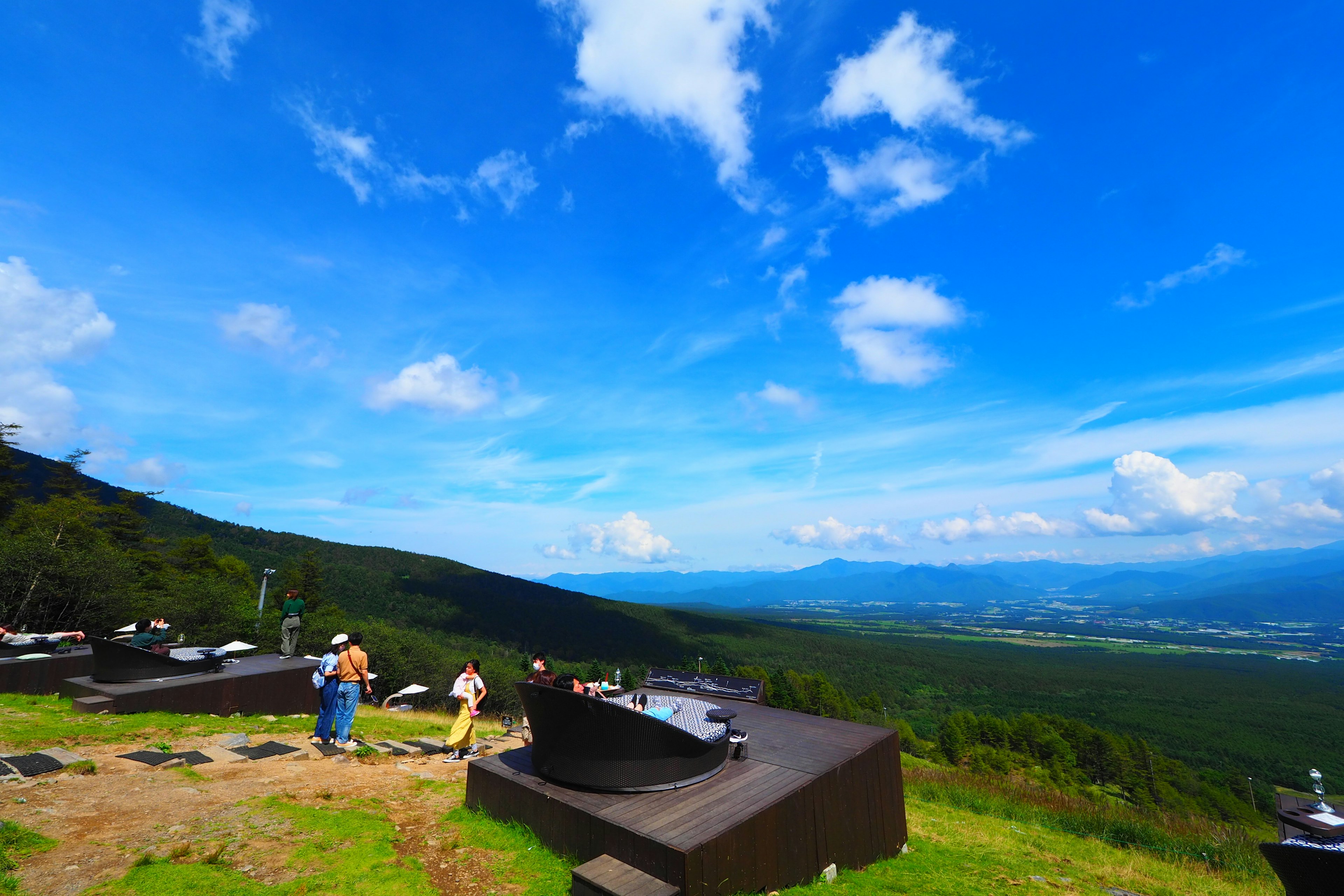 Aussichtspunkt mit blauem Himmel und grünen Bergen