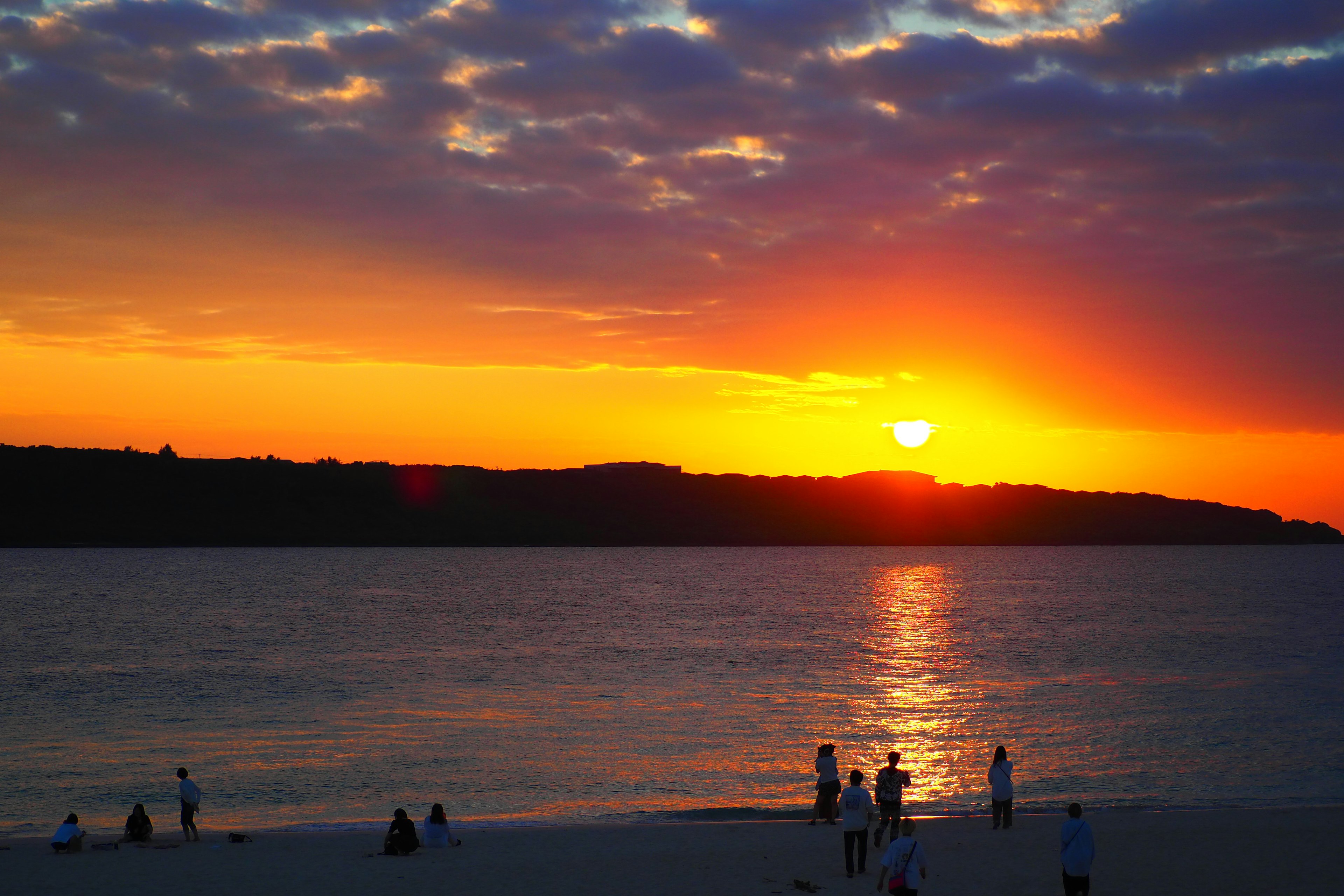 Magnifique coucher de soleil sur l'océan avec des silhouettes de personnes sur la plage