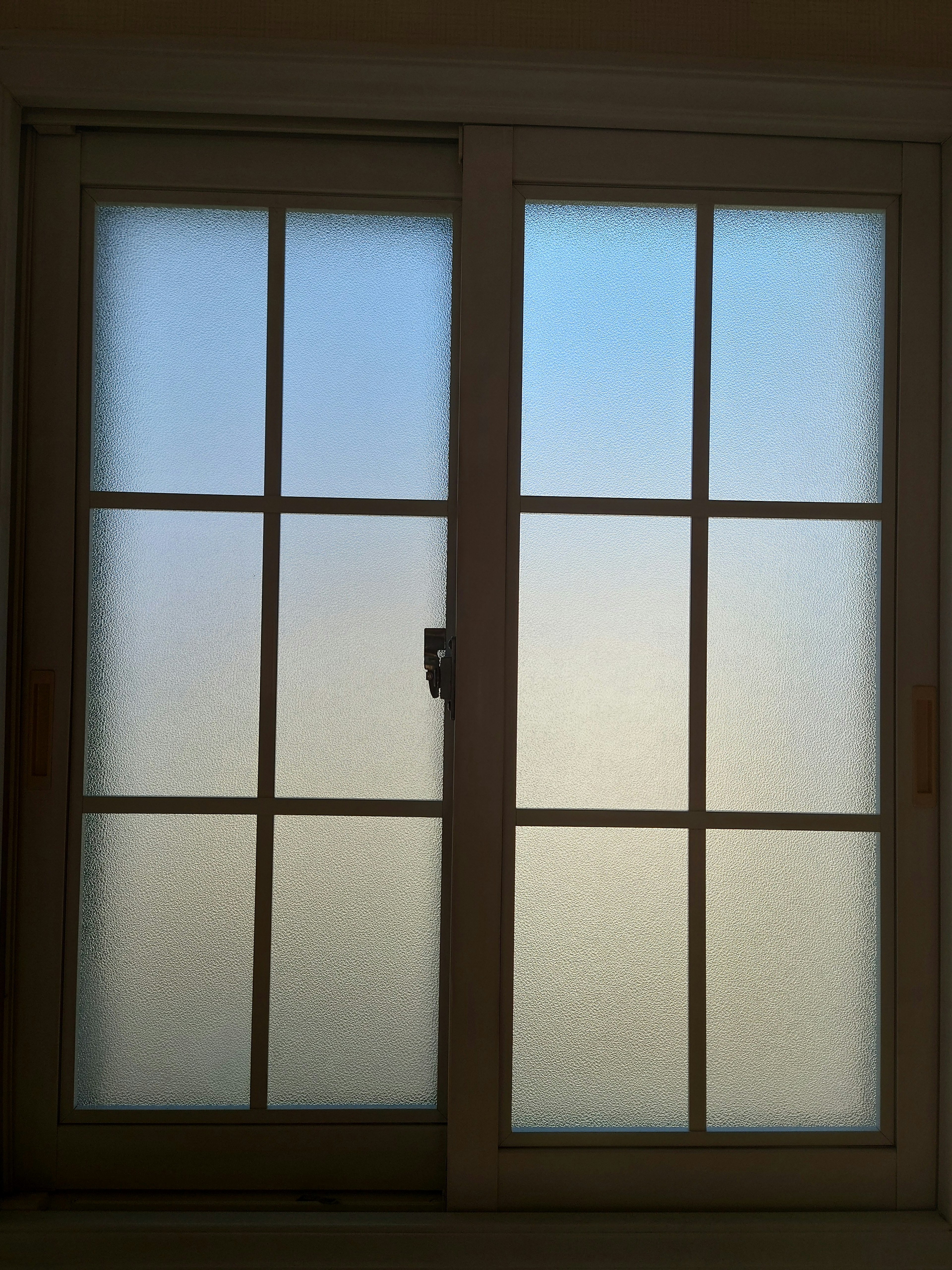 Large white-framed window with a blue sky background