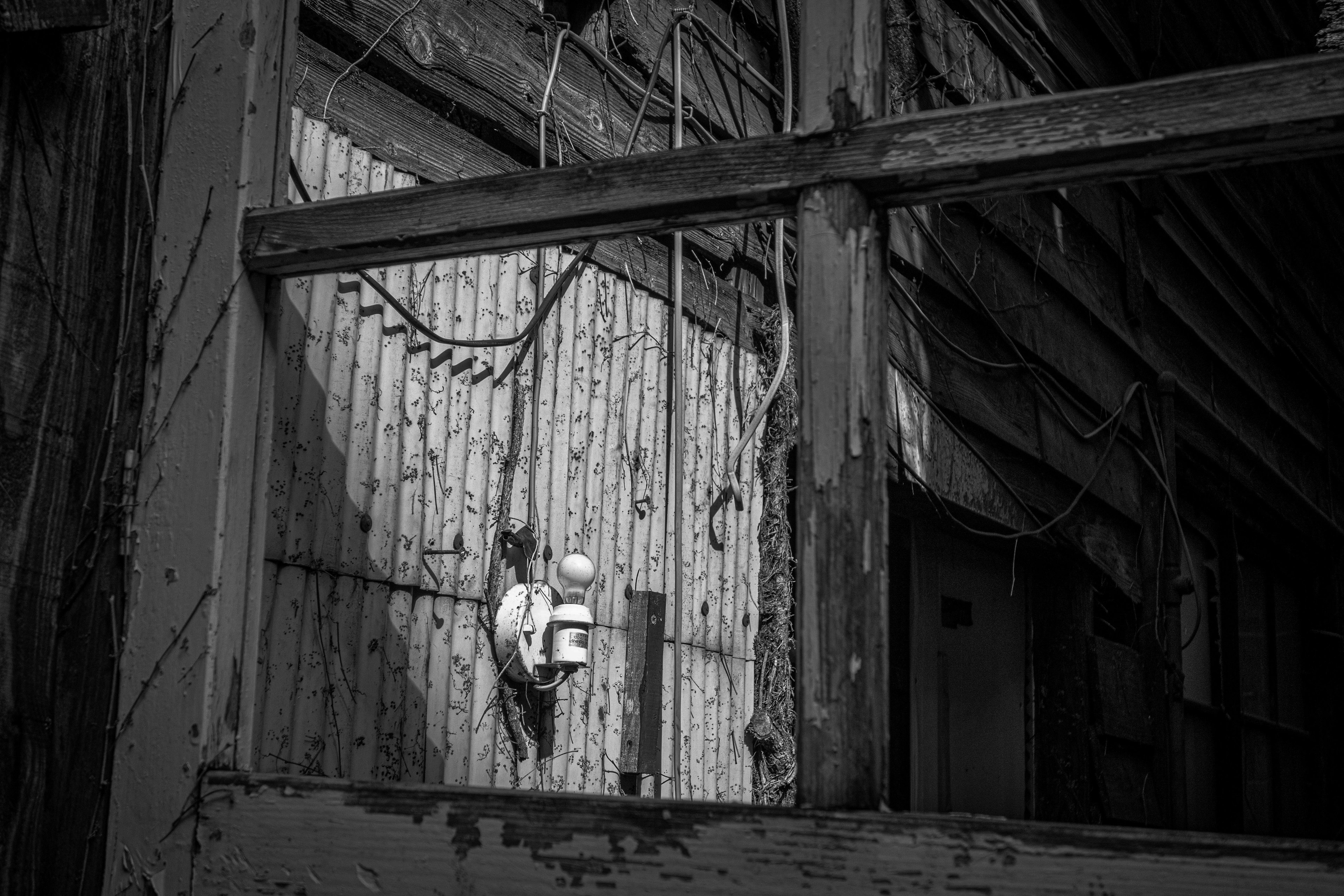 Una persona frente a una vieja pared de edificio en una foto en blanco y negro