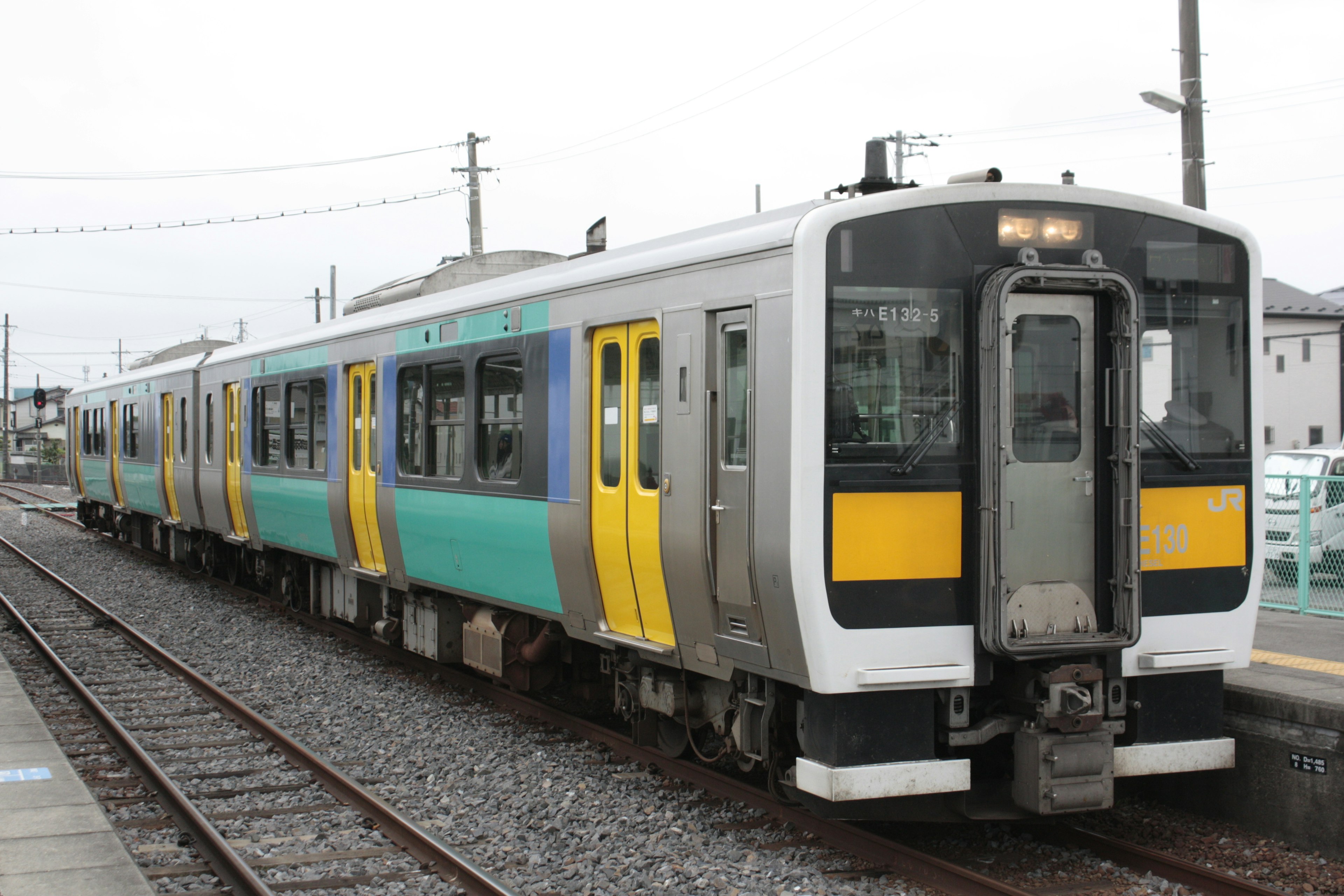 รถไฟที่มีลายเขียวและเหลืองจอดอยู่ที่สถานี