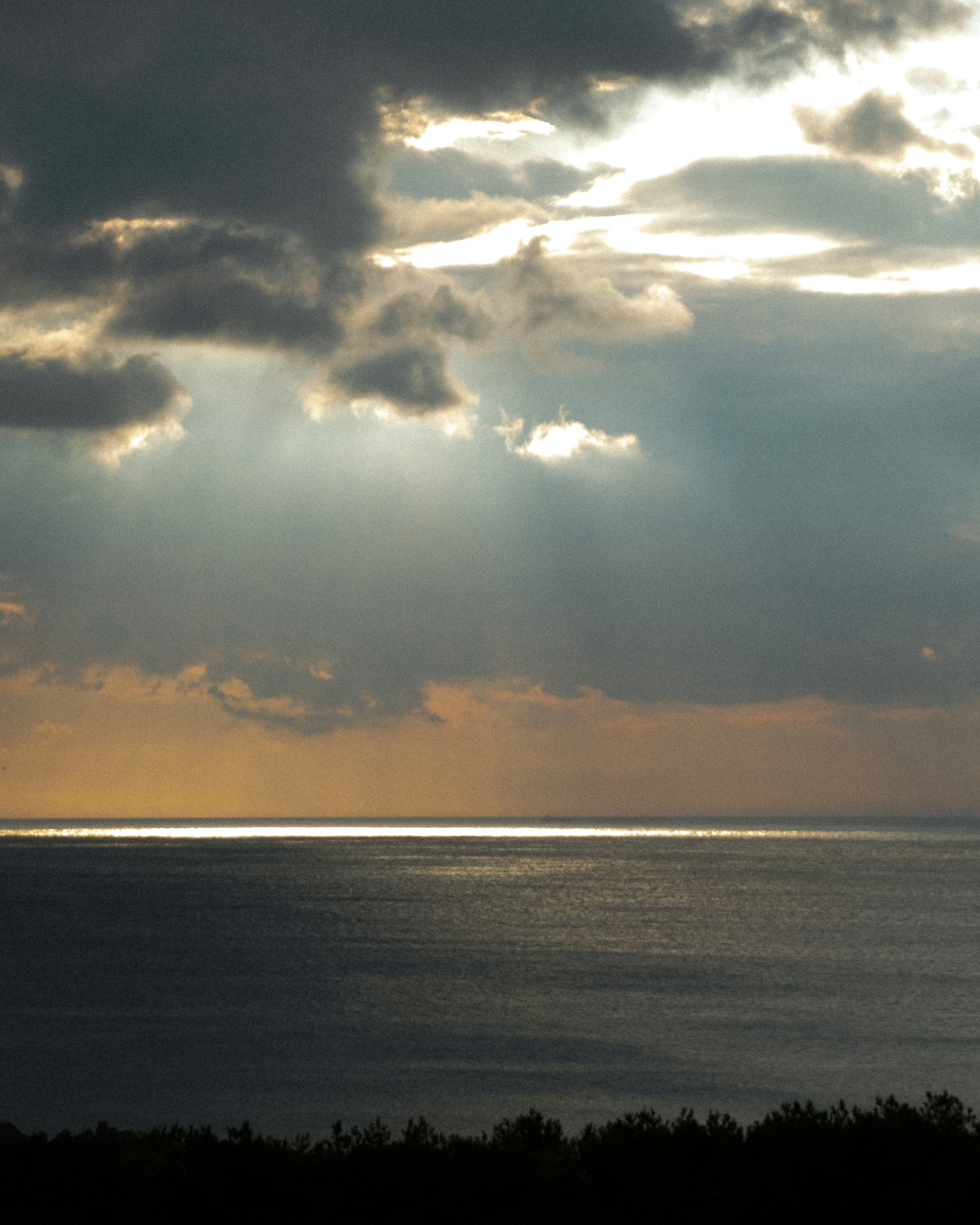 Vista escénica del océano azul y cielo nublado con luz reflejándose en la superficie del agua