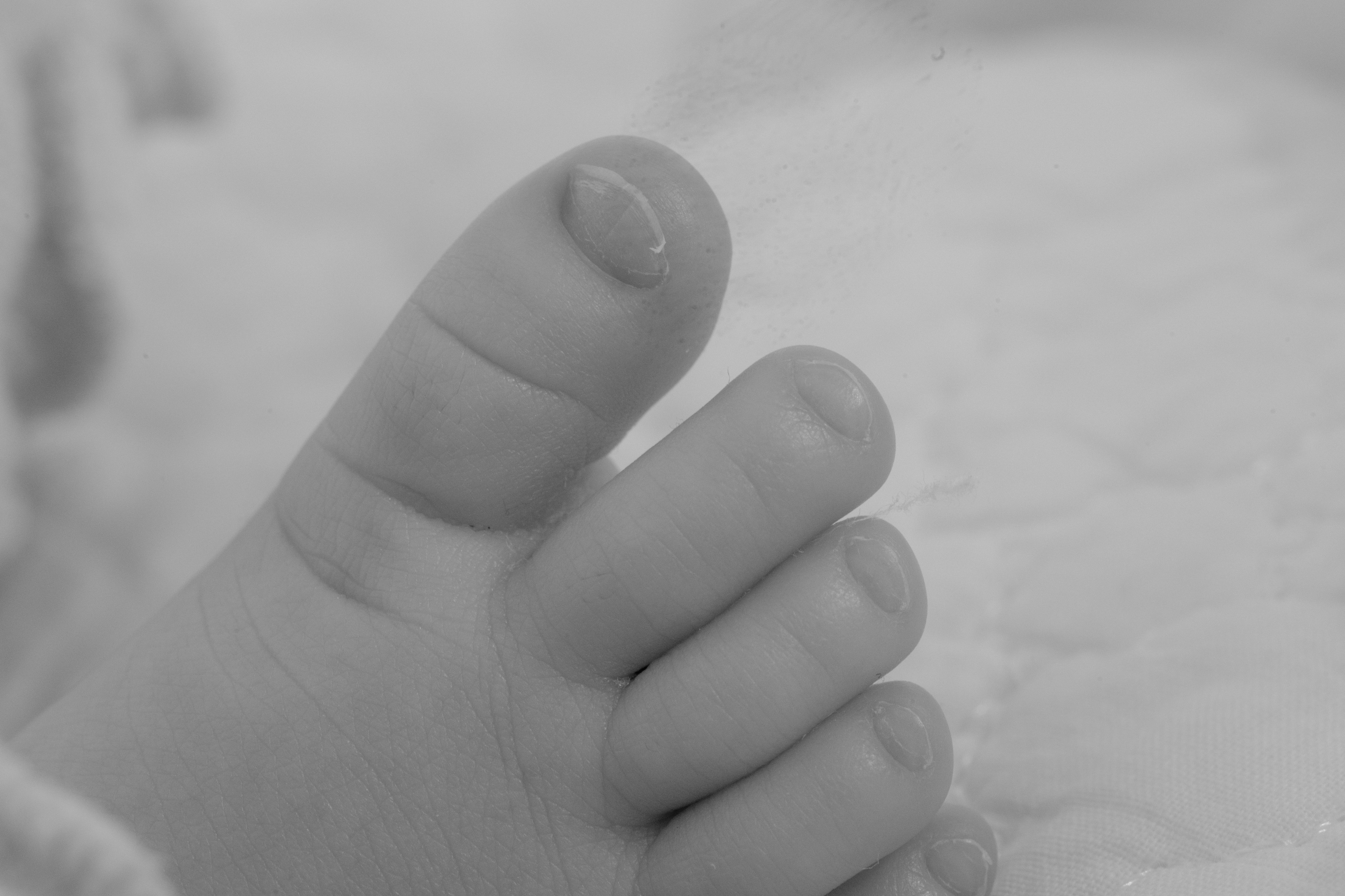 Close-up of a baby's foot showing the big toe and other toes in black and white