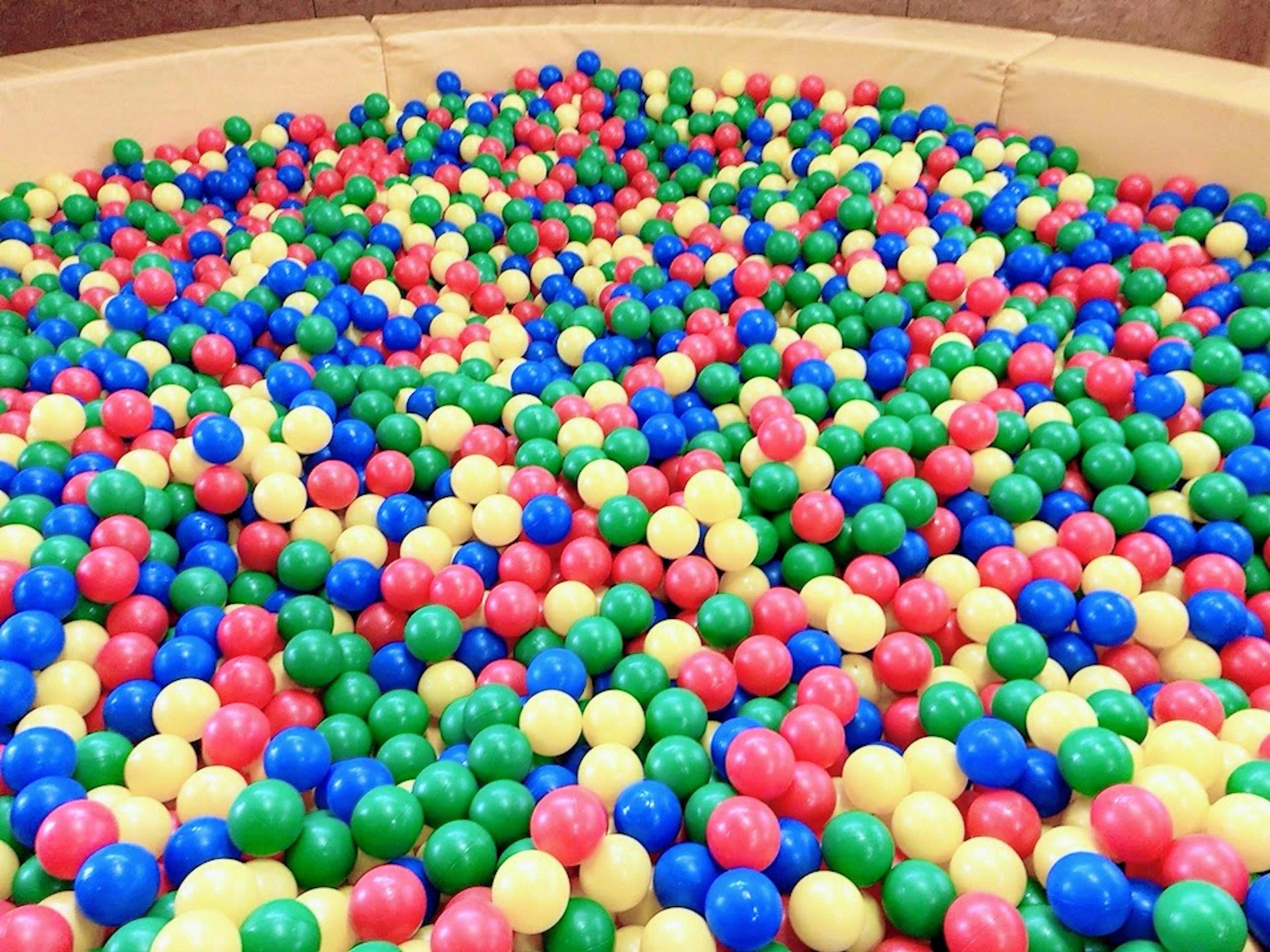 A vibrant ball pit filled with colorful plastic balls in various colors