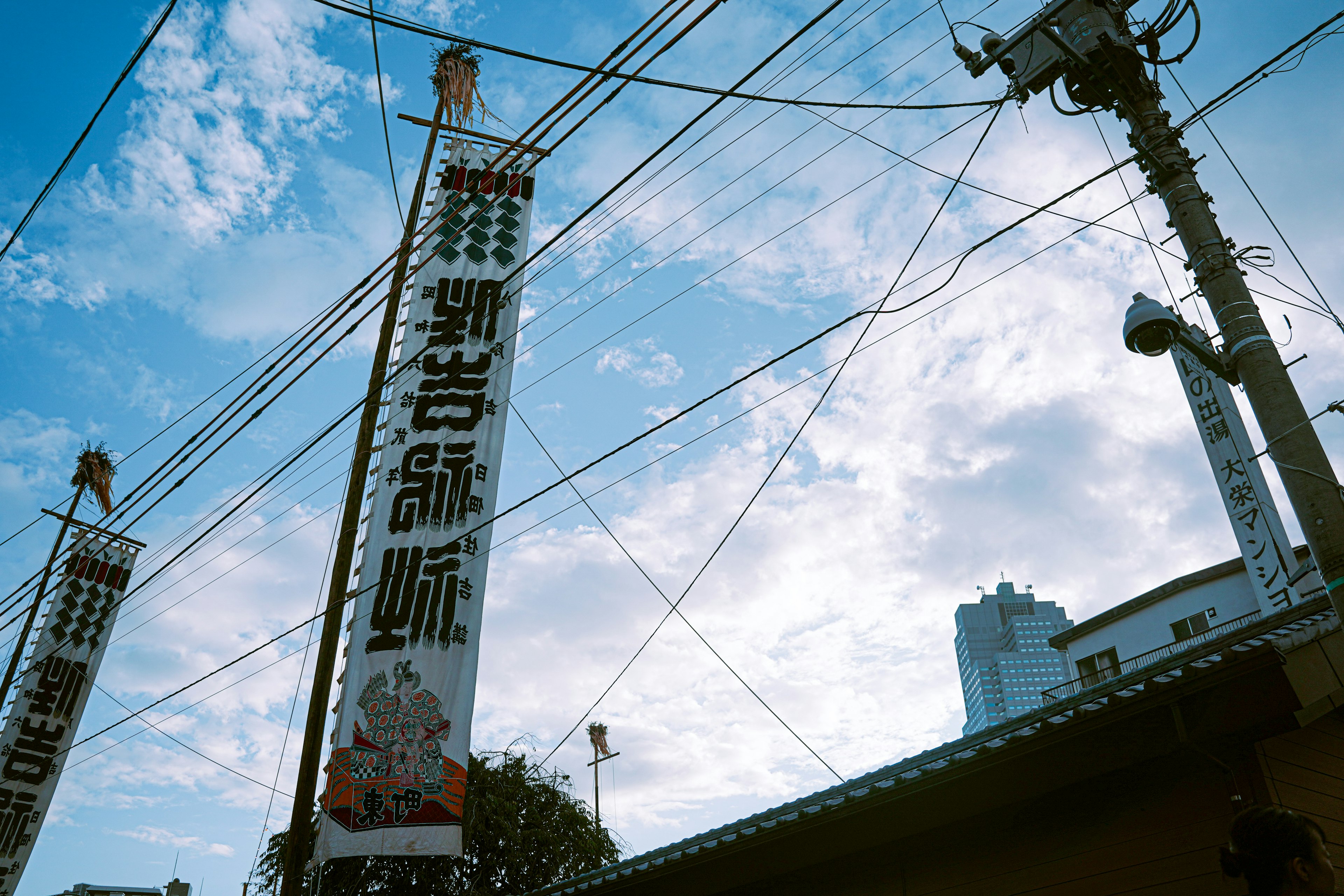 A photo of large banners and buildings under a blue sky with power lines