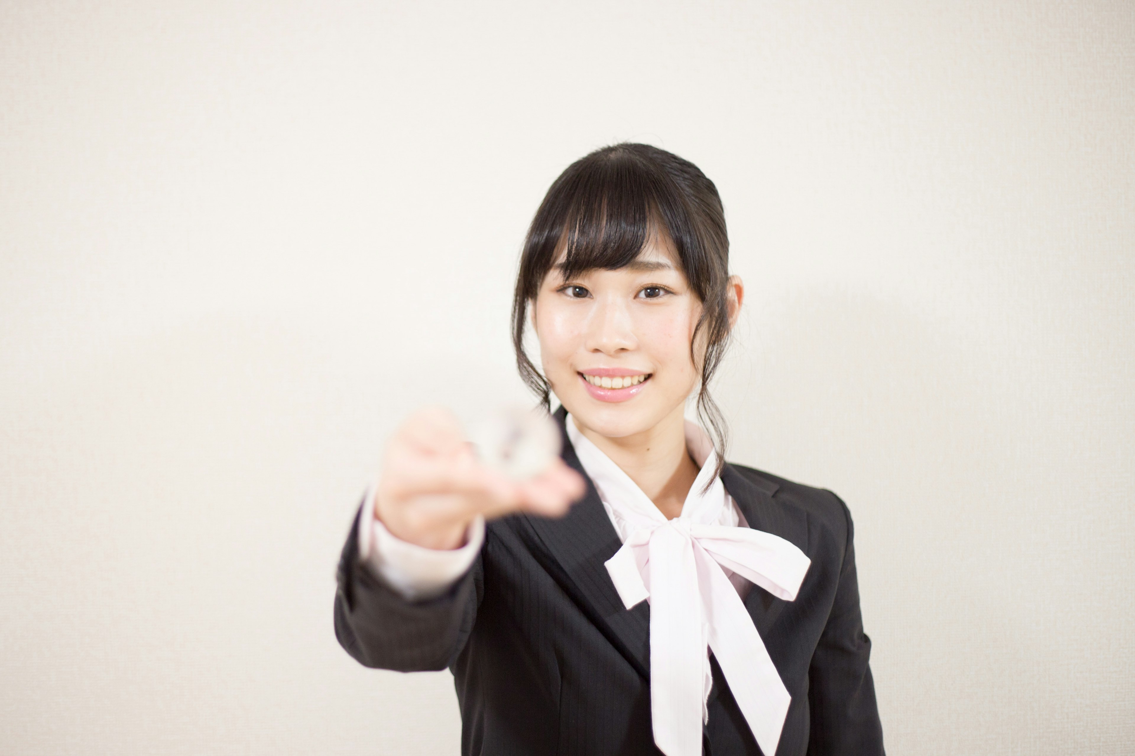 A smiling woman in a business suit extending her hand