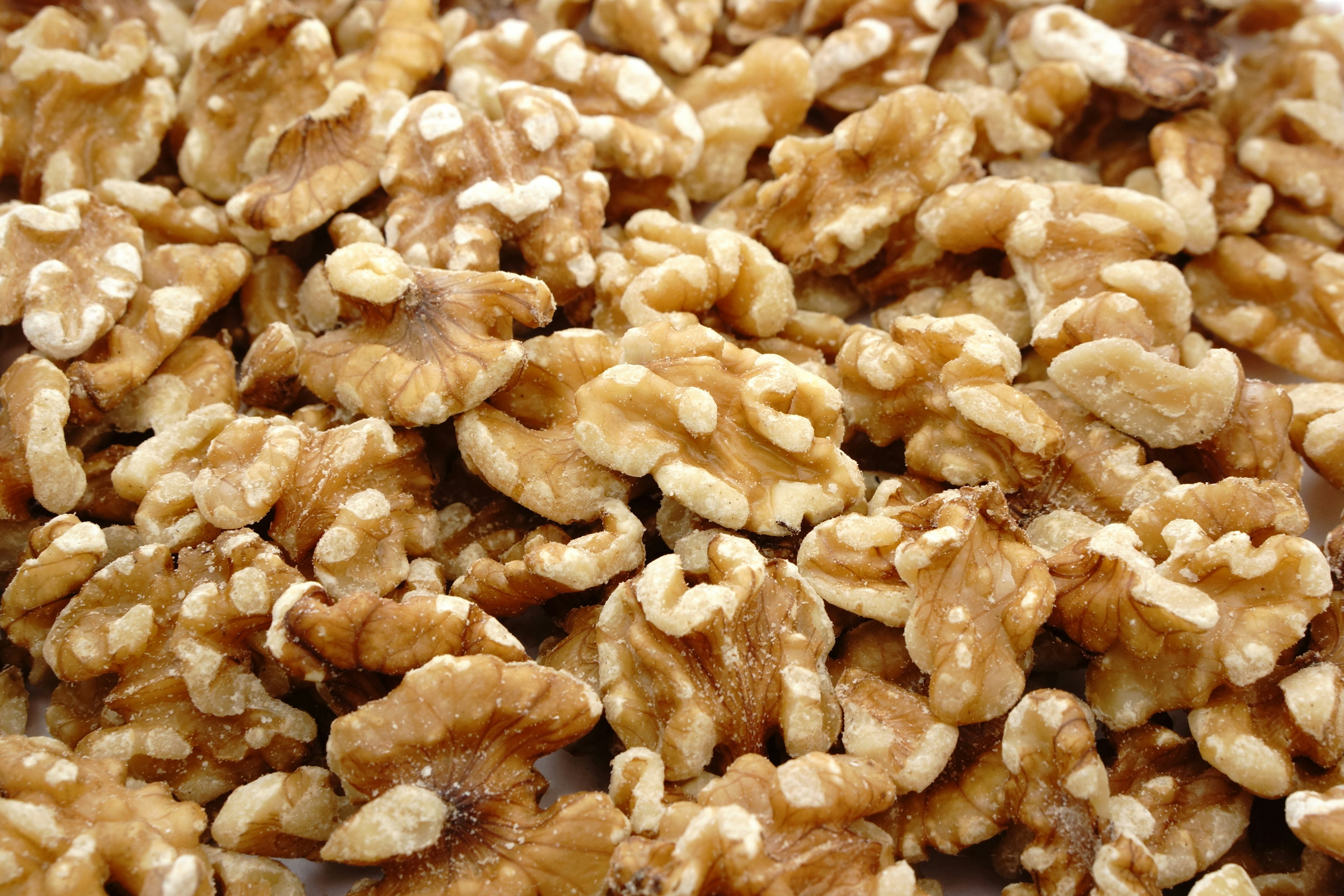 A close-up of shelled walnuts in various shapes and textures