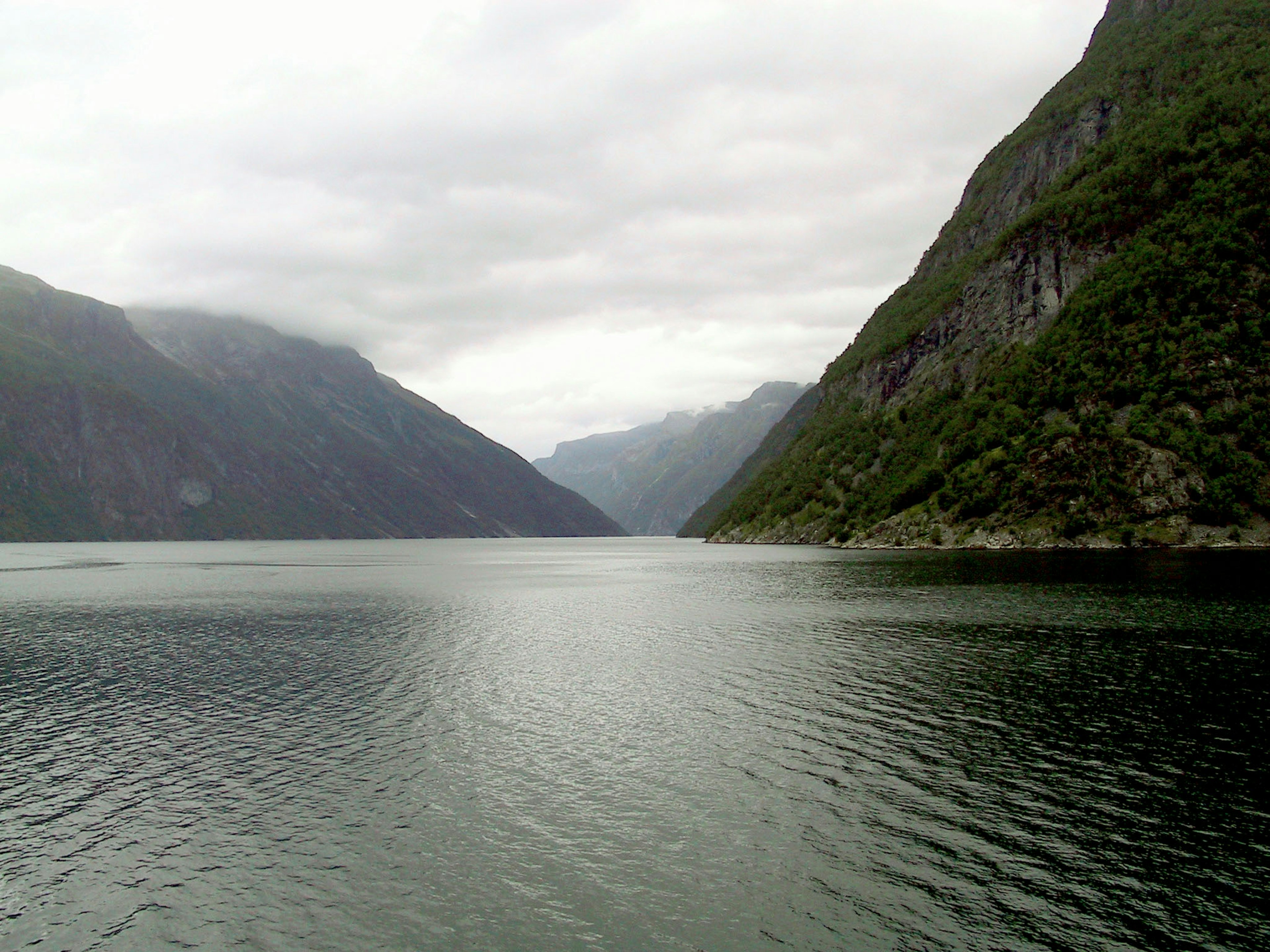 Misty fjord landscape with calm water surface