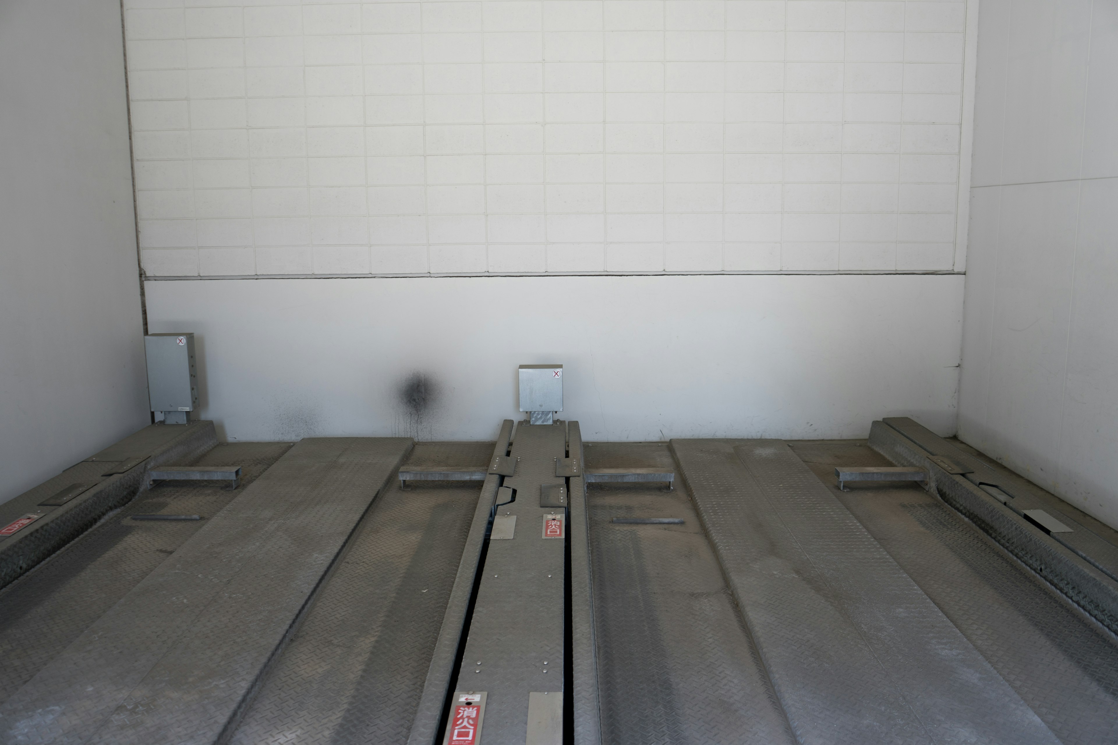 Interior of a trailer with a blank wall and metal floor