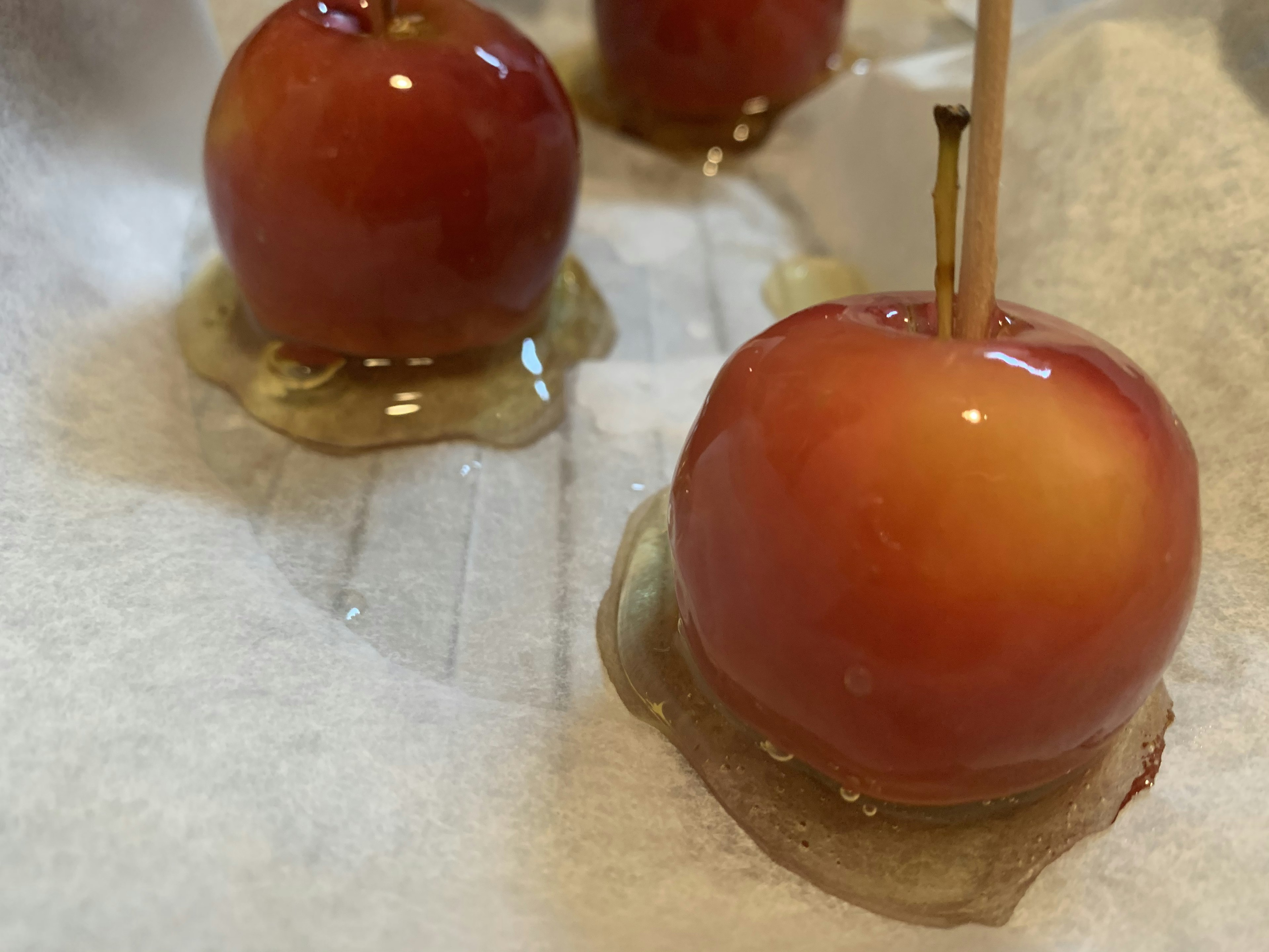 Foto de manzanas cubiertas de caramelo sobre papel pergamino