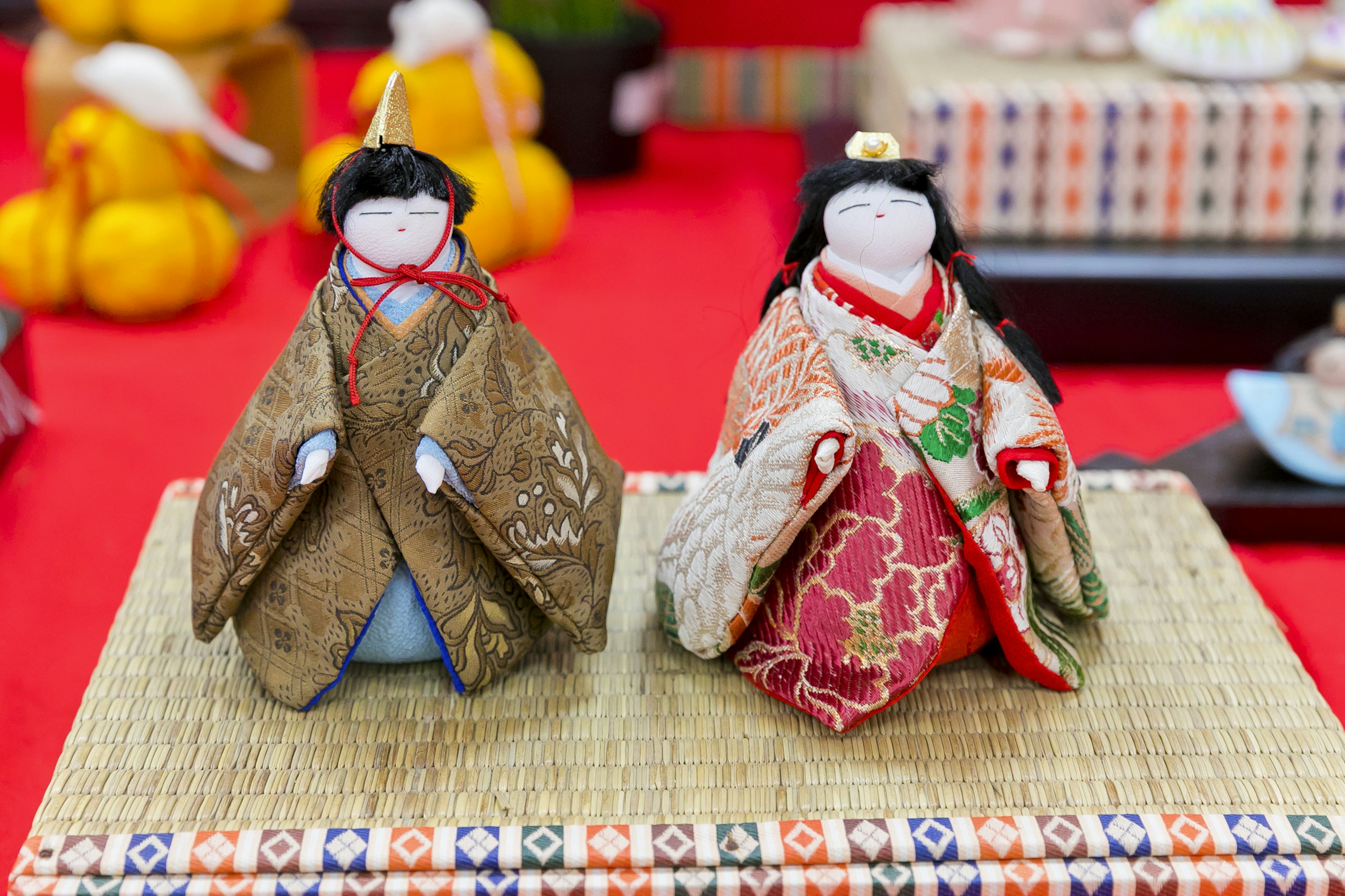 Poupées hina japonaises traditionnelles exposées sur un tissu rouge