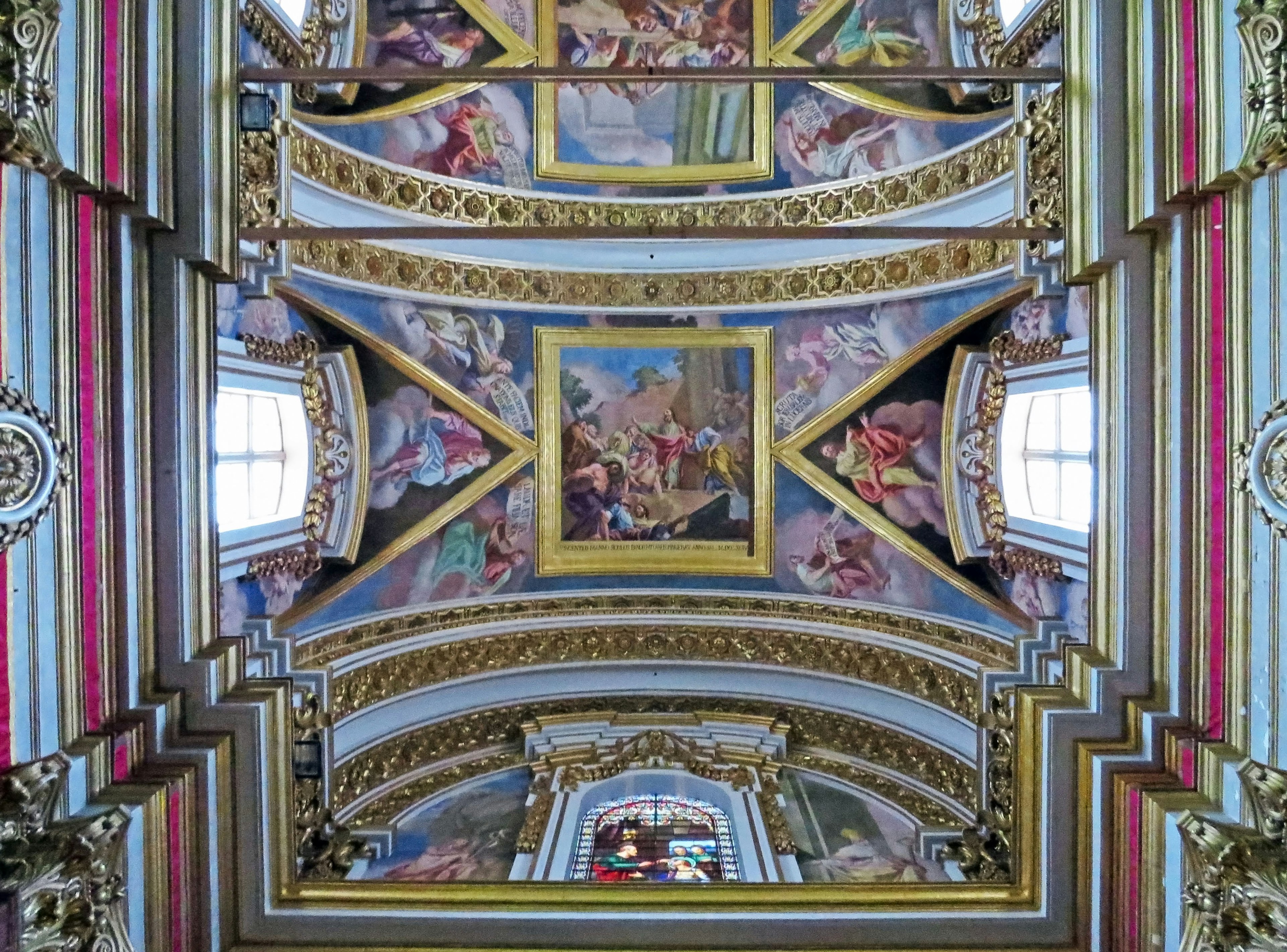 Hermoso techo pintado al fresco con decoraciones doradas en el interior de una iglesia