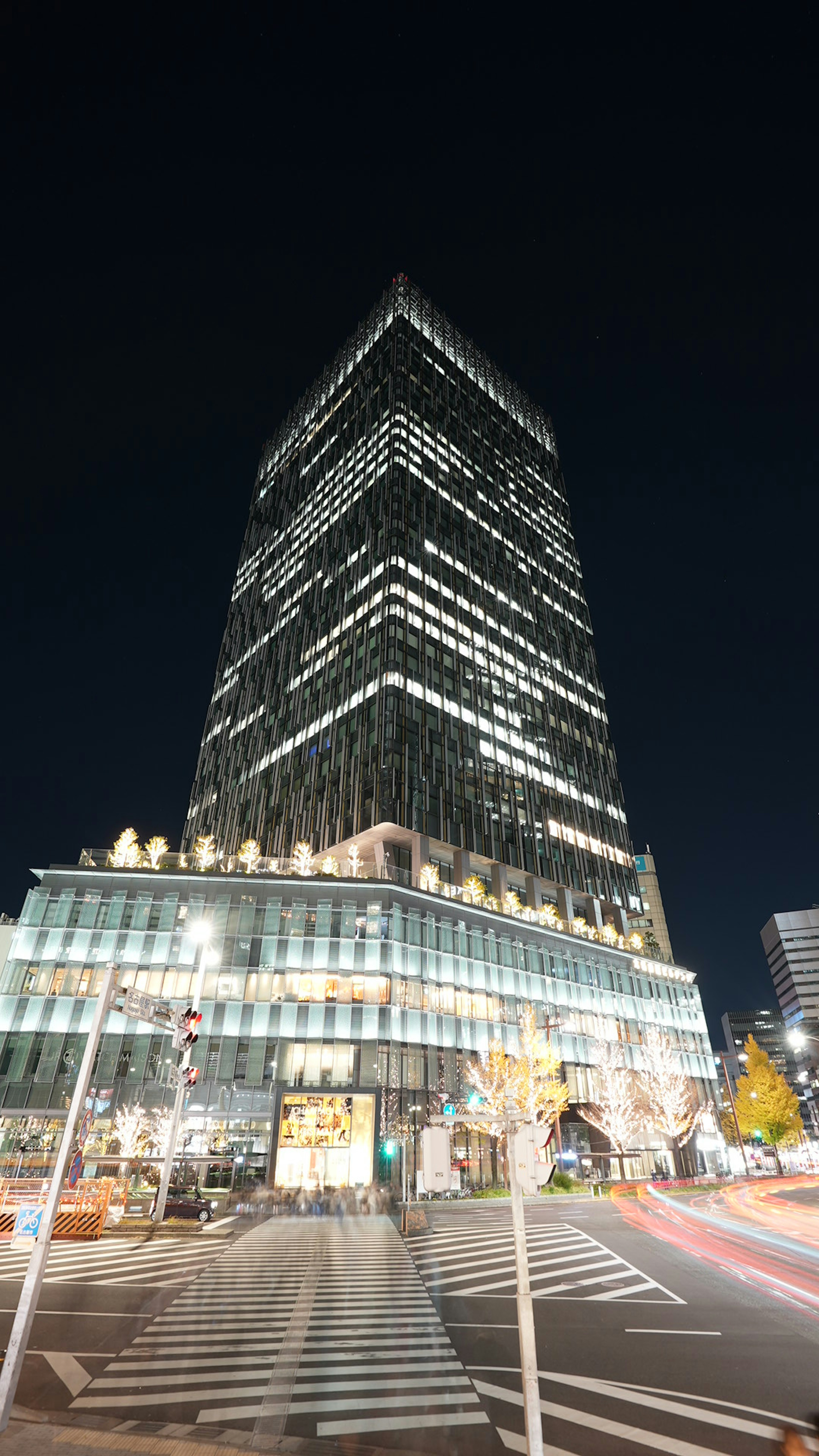 Photo of a skyscraper towering at night bright windows and modern design features