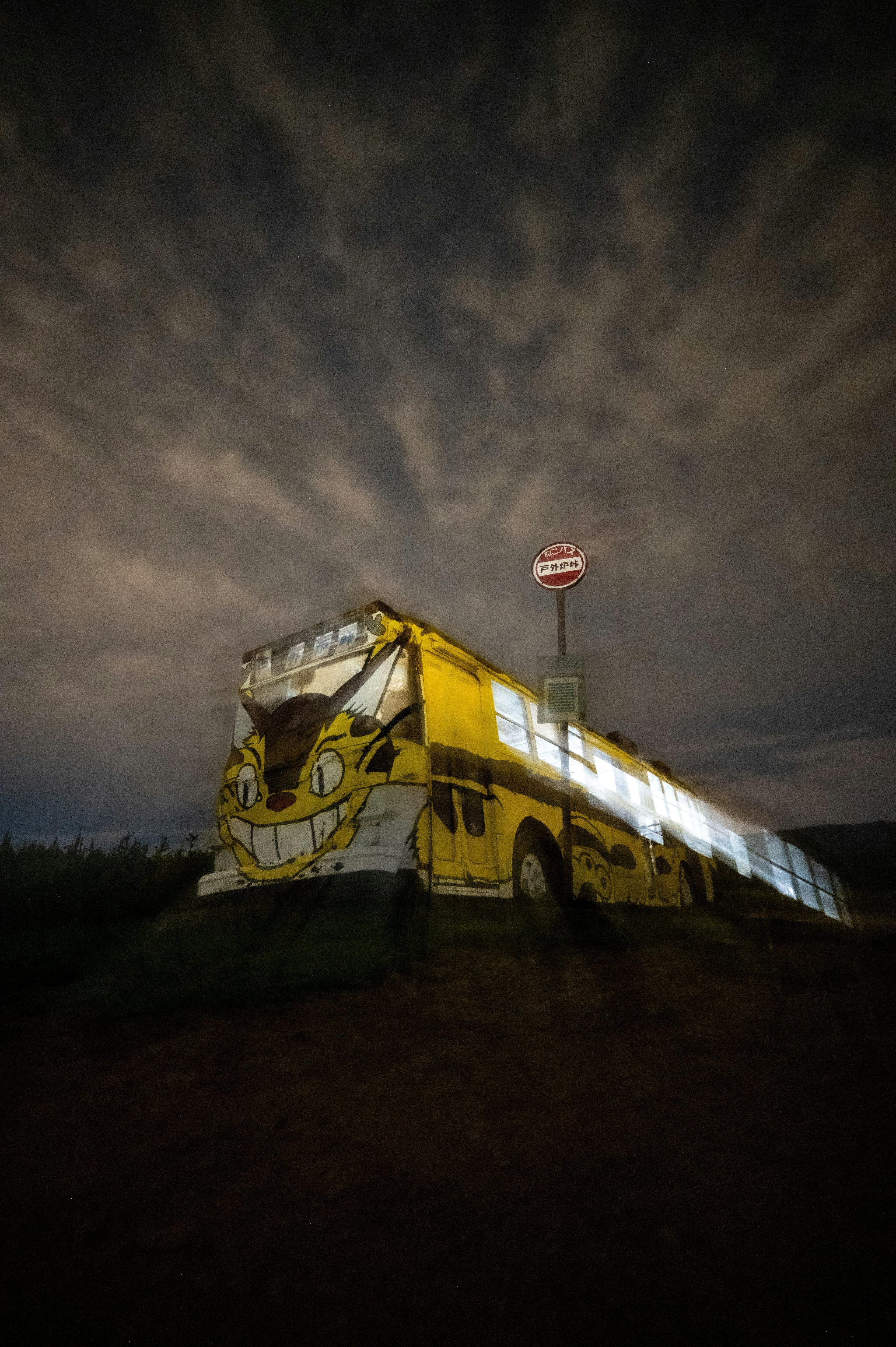 Autobus giallo artistico contro un cielo notturno drammatico