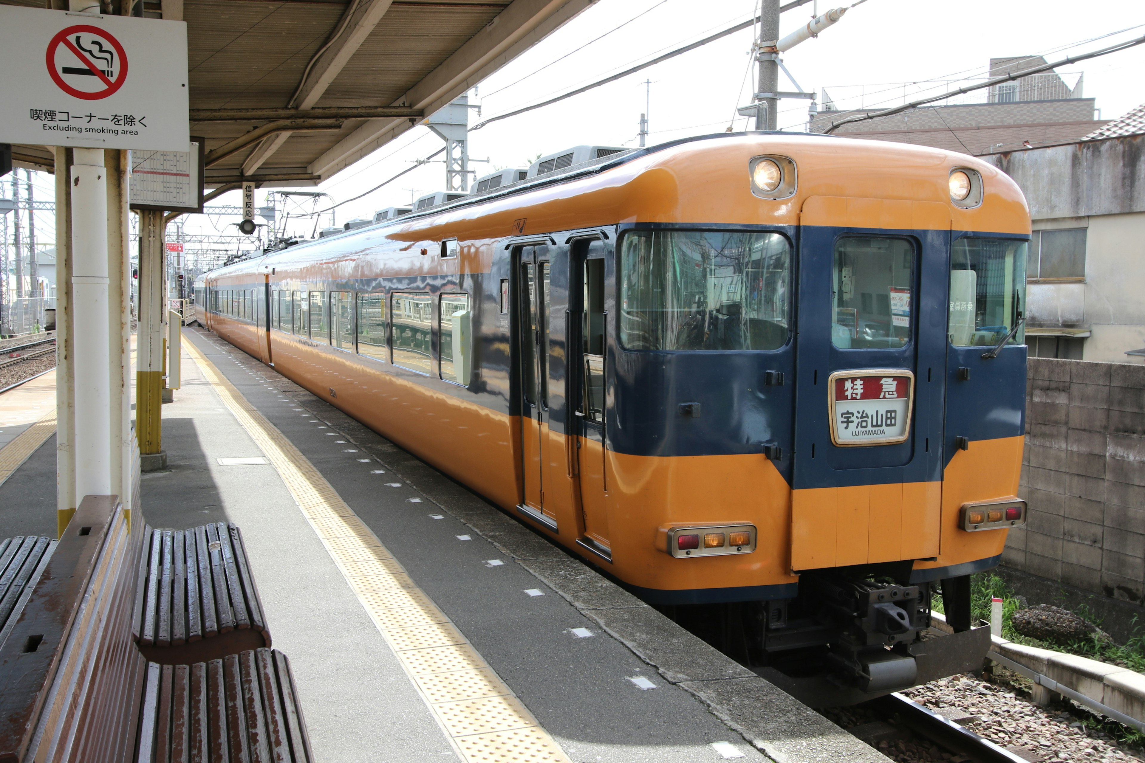 Un train orange est arrêté sur un quai de la gare