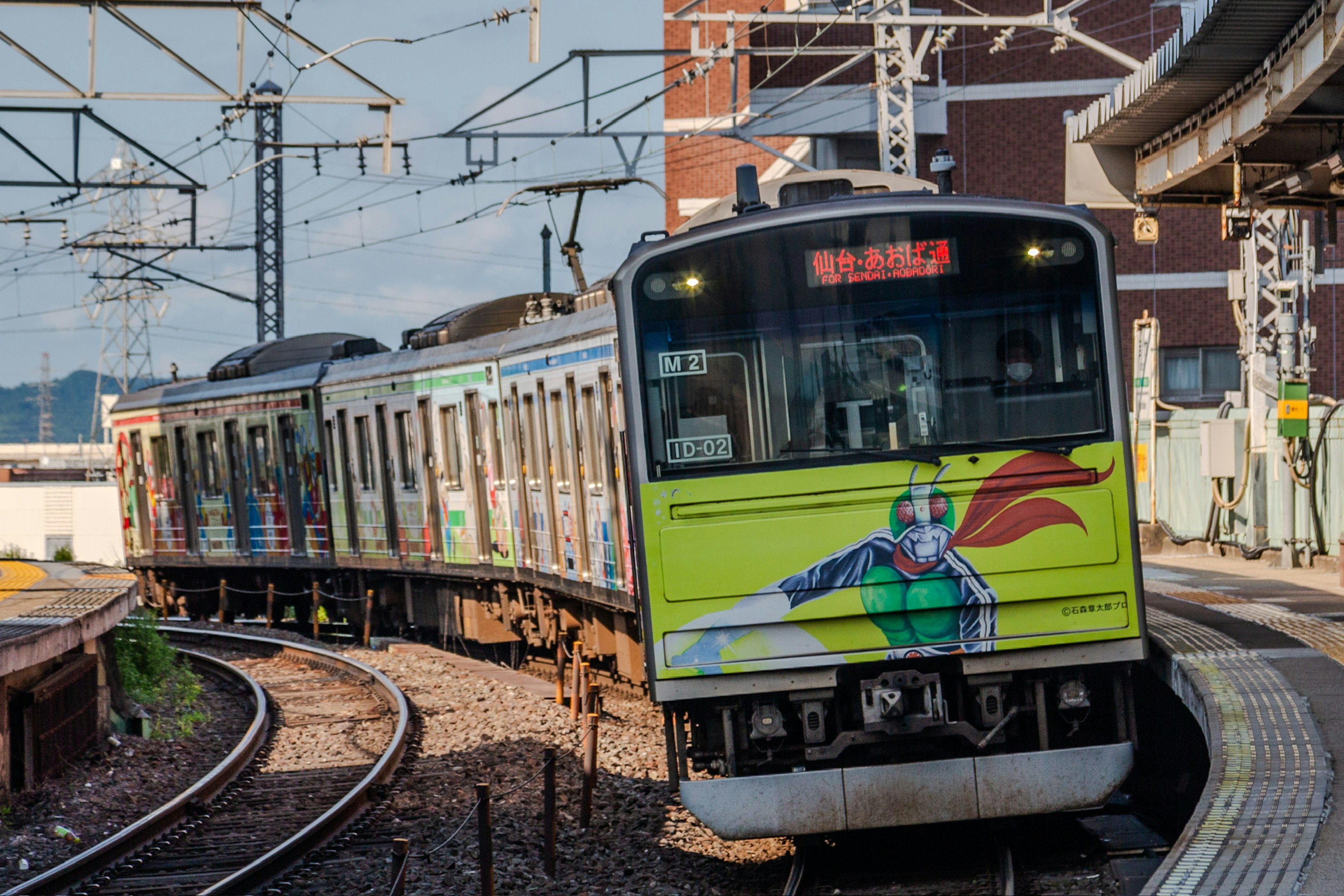 Treno colorato su binari curvi in una stazione