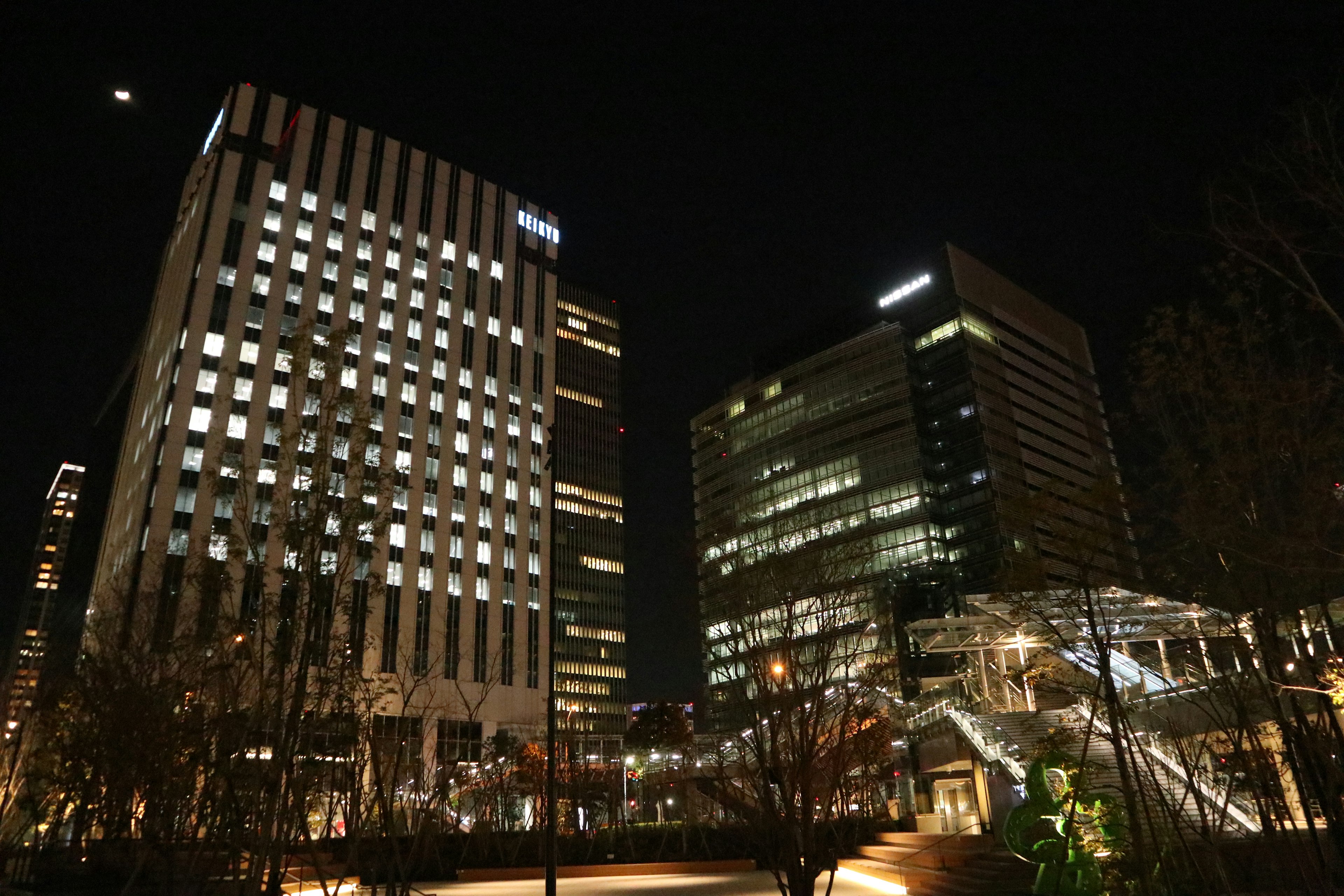 夜の都市風景に立つ高層ビル群と明るい窓の光