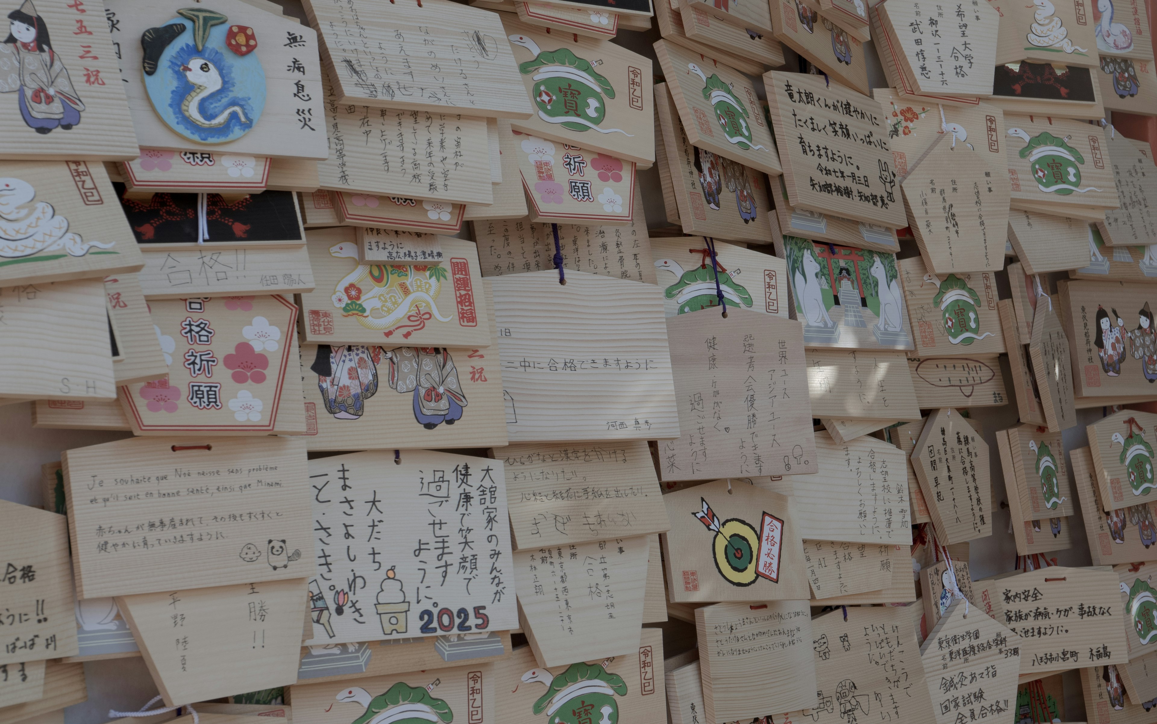 Plaques en bois avec divers messages et illustrations accrochées à un mur