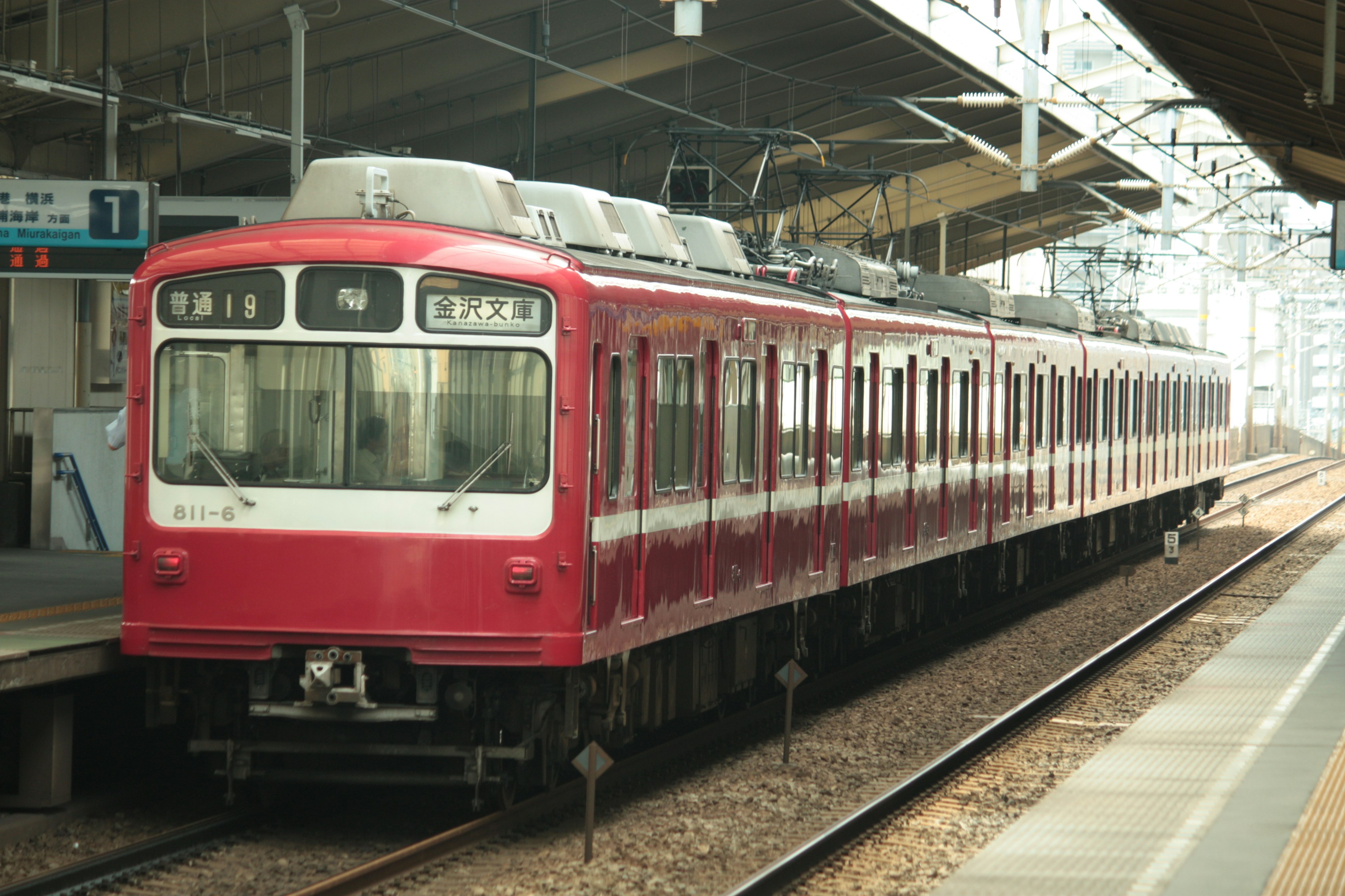 Kereta merah diparkir di platform stasiun