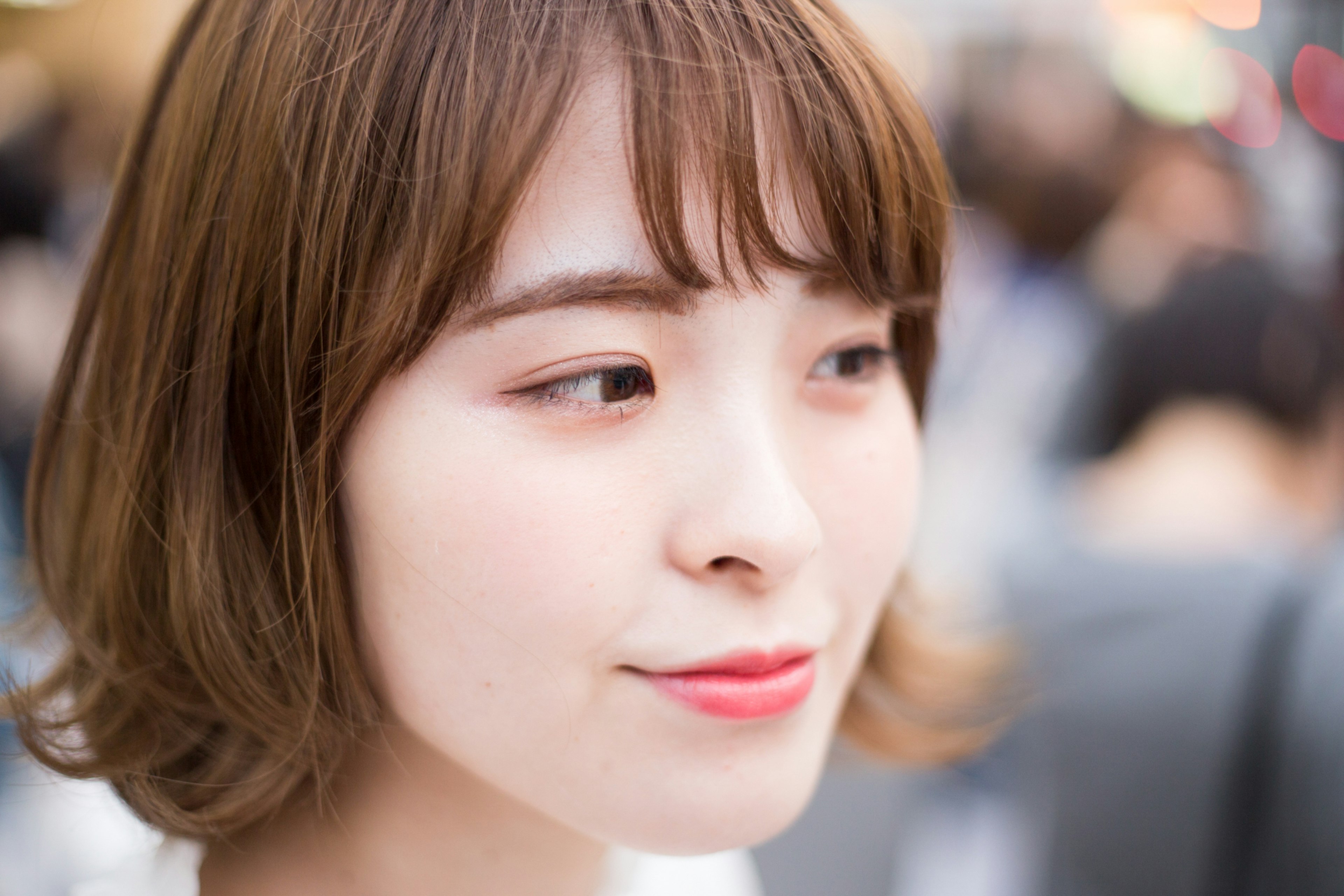 Portrait of a young woman with a smile blurred crowd in the background