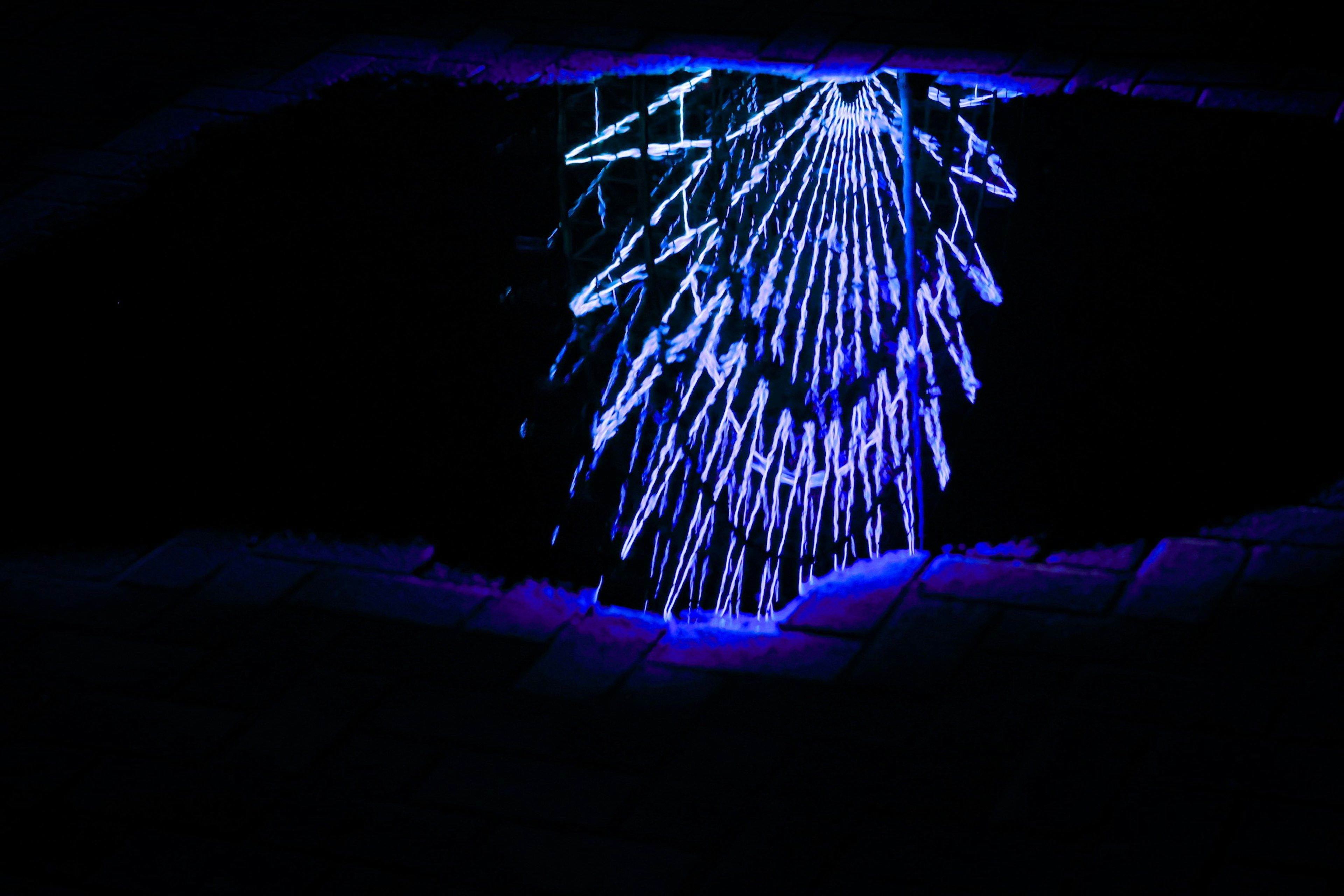 Image de formations en forme de stalactites illuminées par une lumière bleue