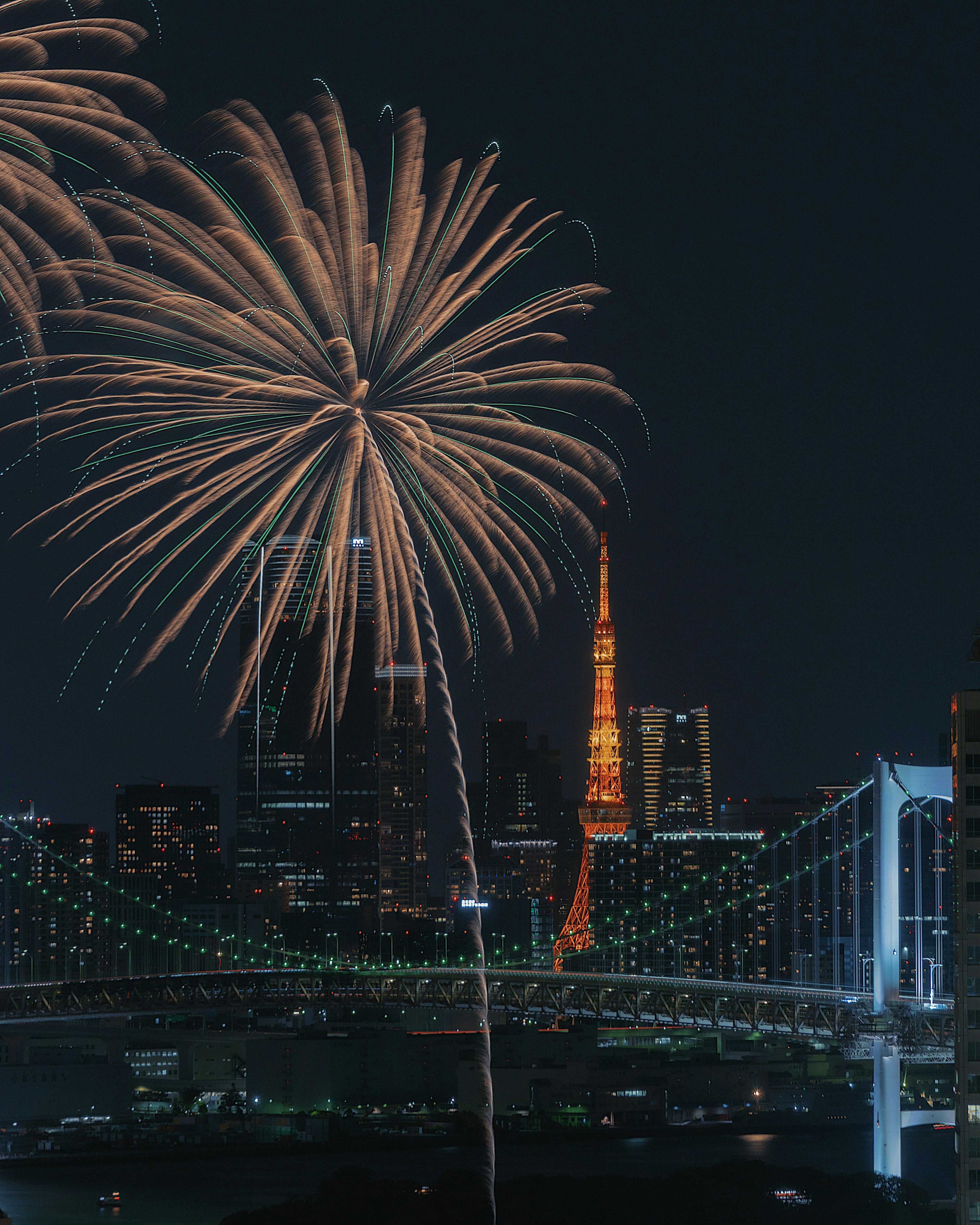 Espectáculo de fuegos artificiales sobre la Torre de Tokio y el Puente Rainbow de noche