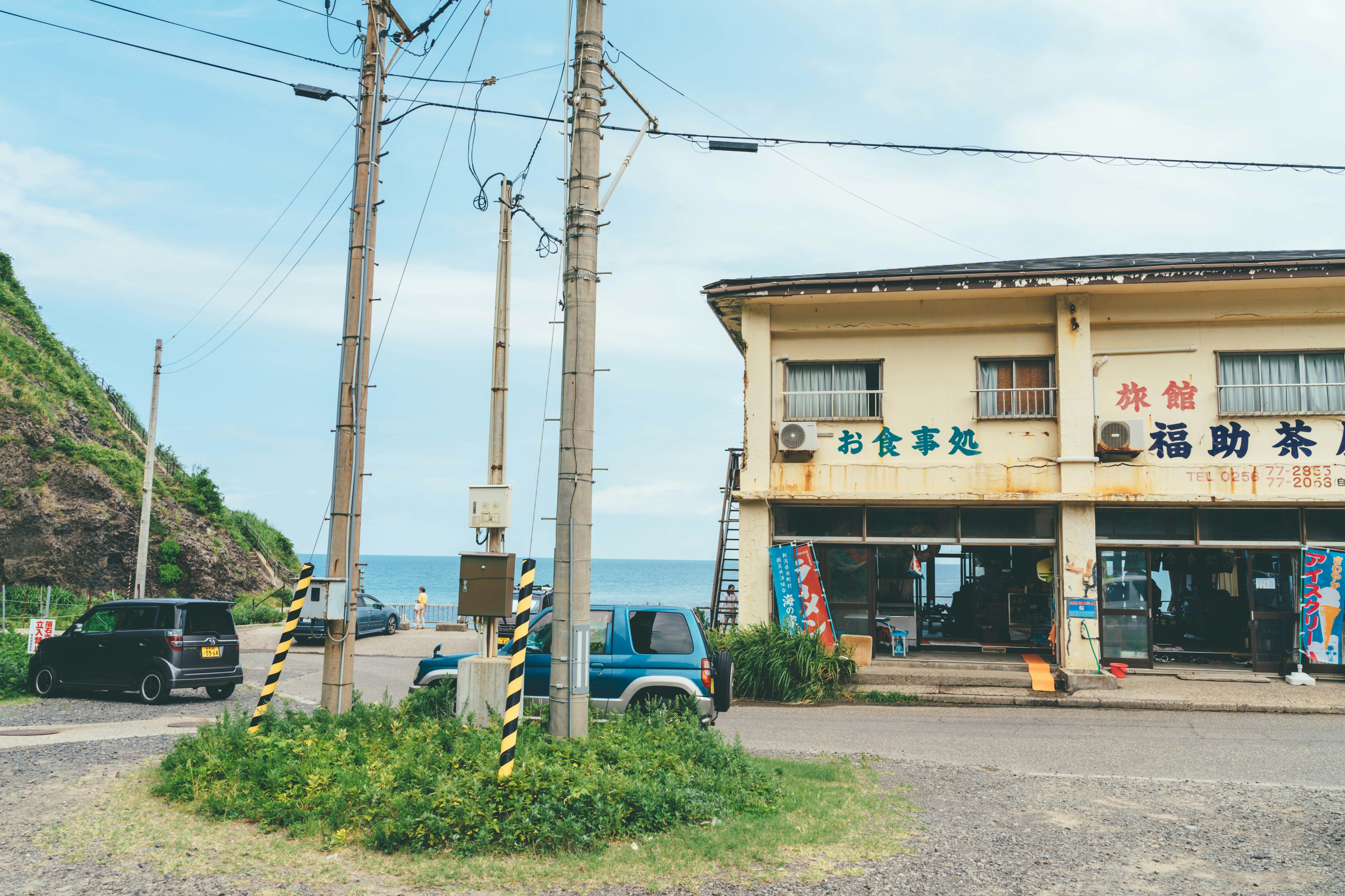 Vecchio negozio vicino al mare con pali elettrici