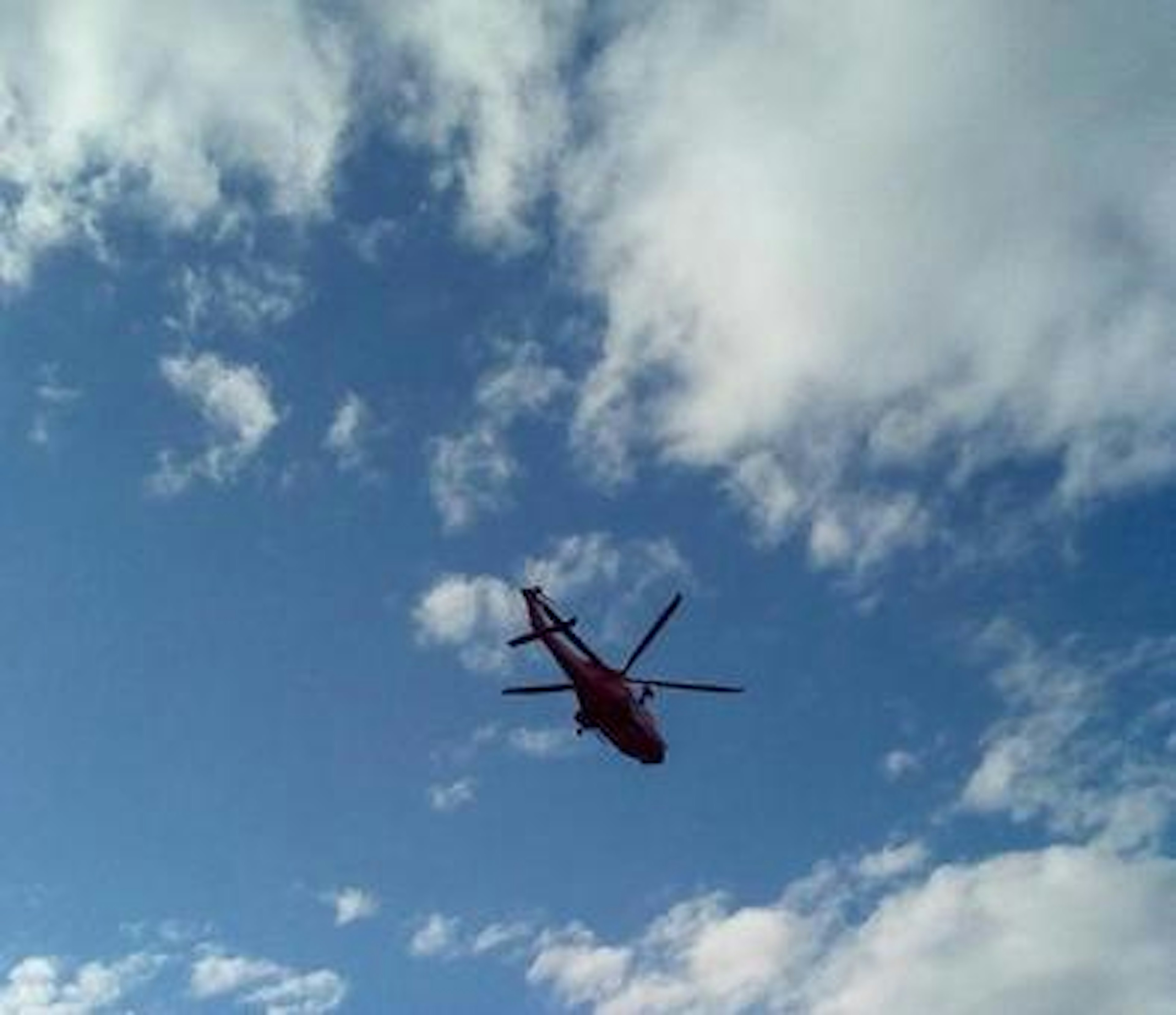 Elicottero rosso che vola contro un cielo blu