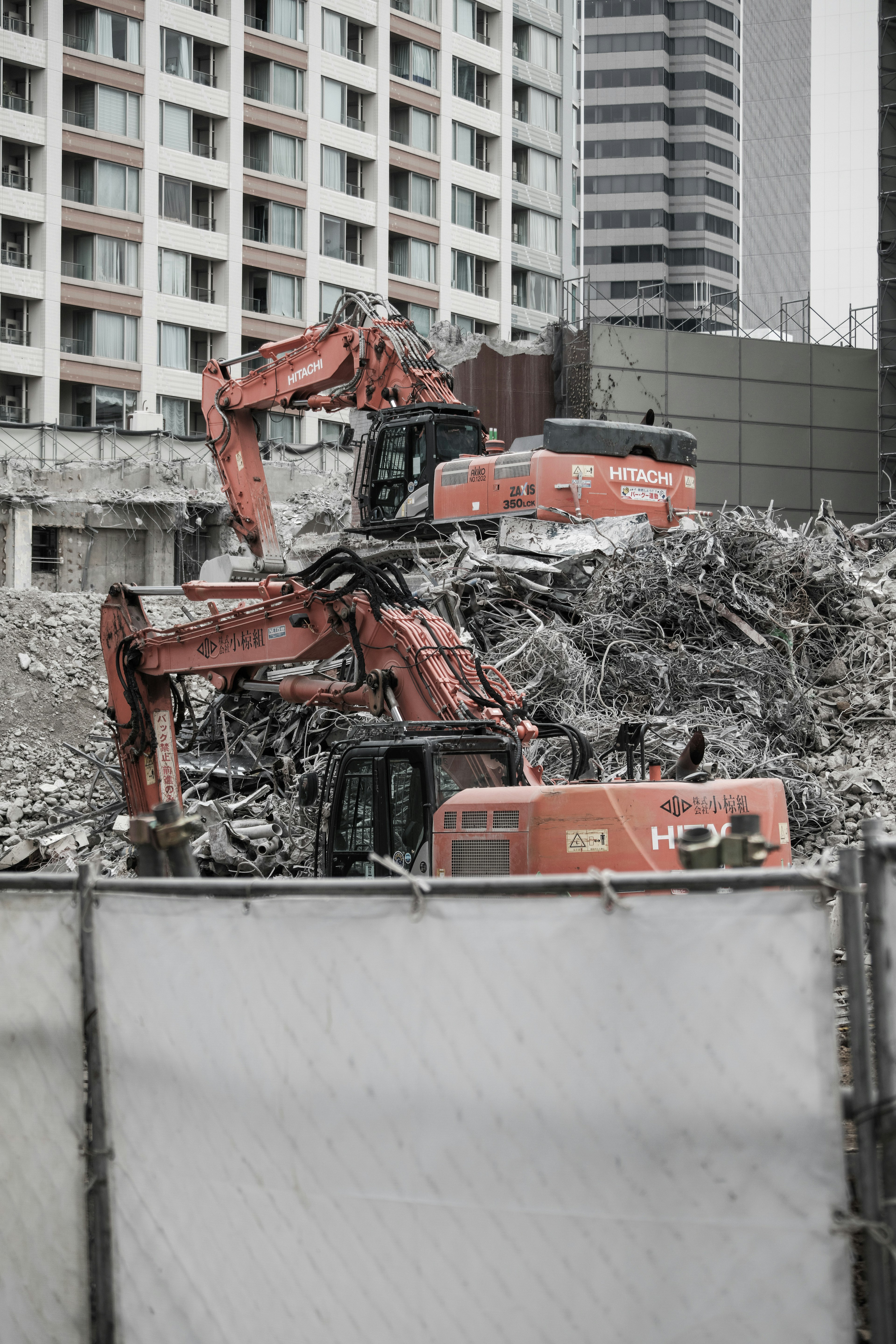 Construction machinery on a pile of debris at a demolition site