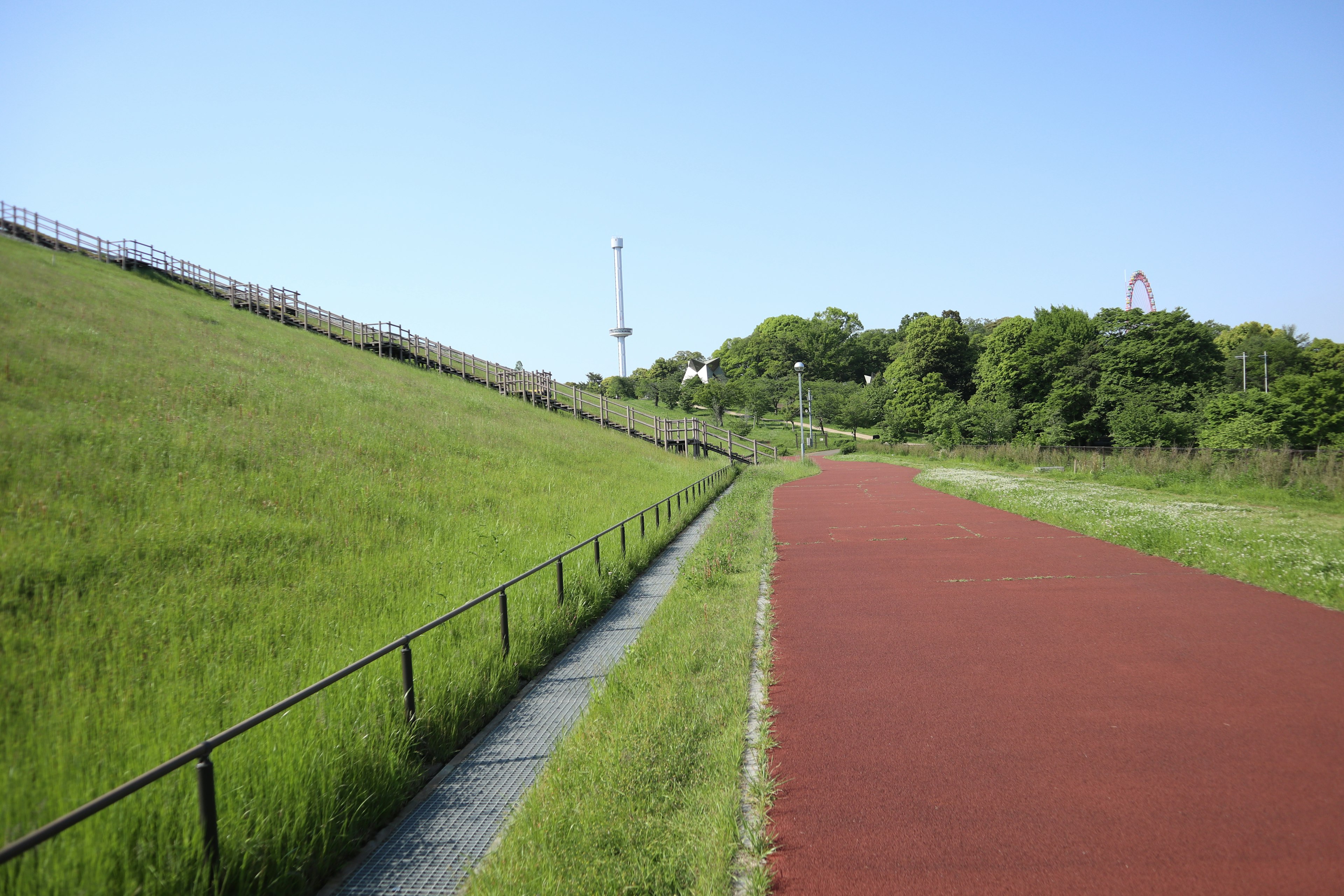 緑の草地と赤いトラックの風景で青い空の下