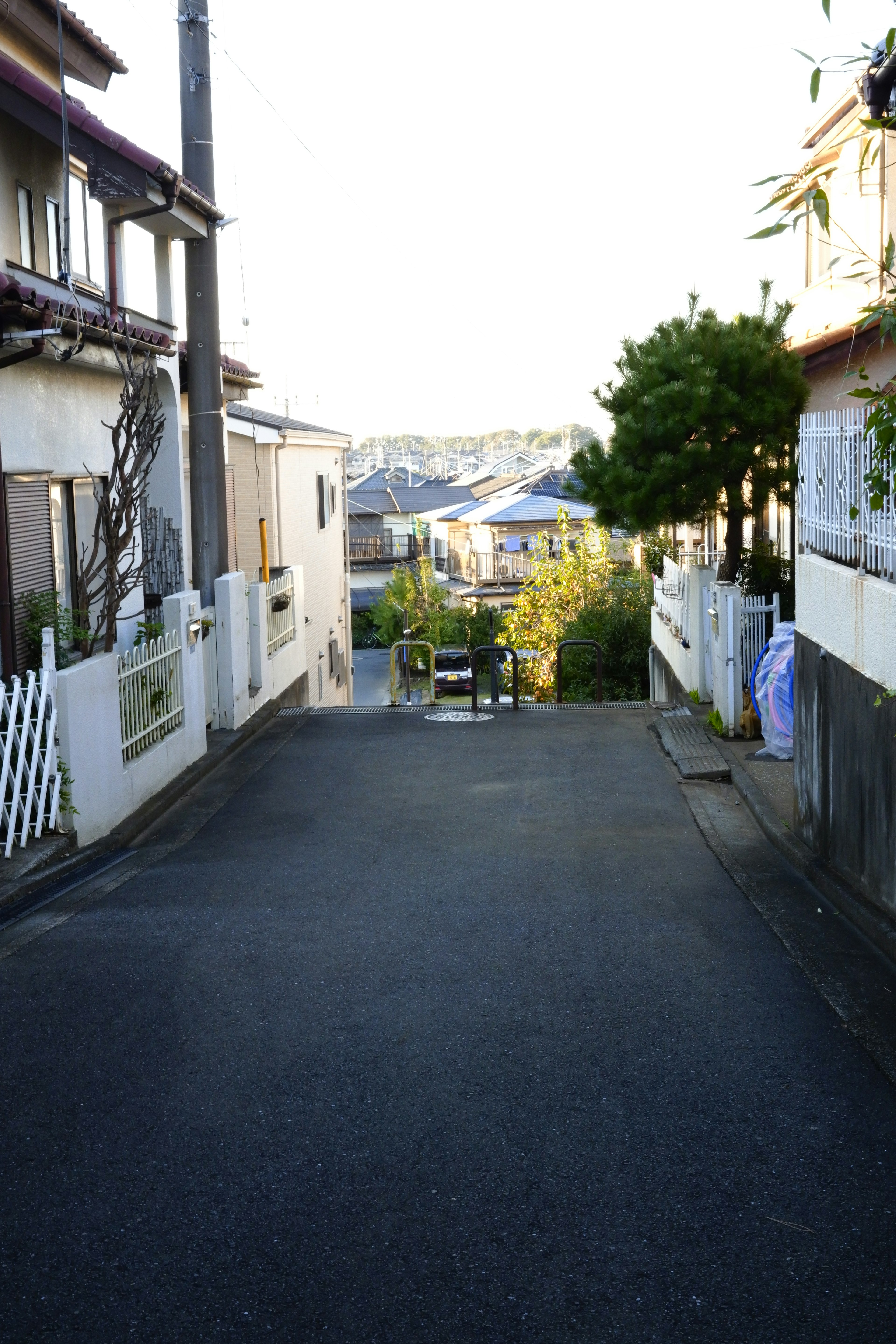 静かな住宅街の坂道で周囲に家々が並ぶ