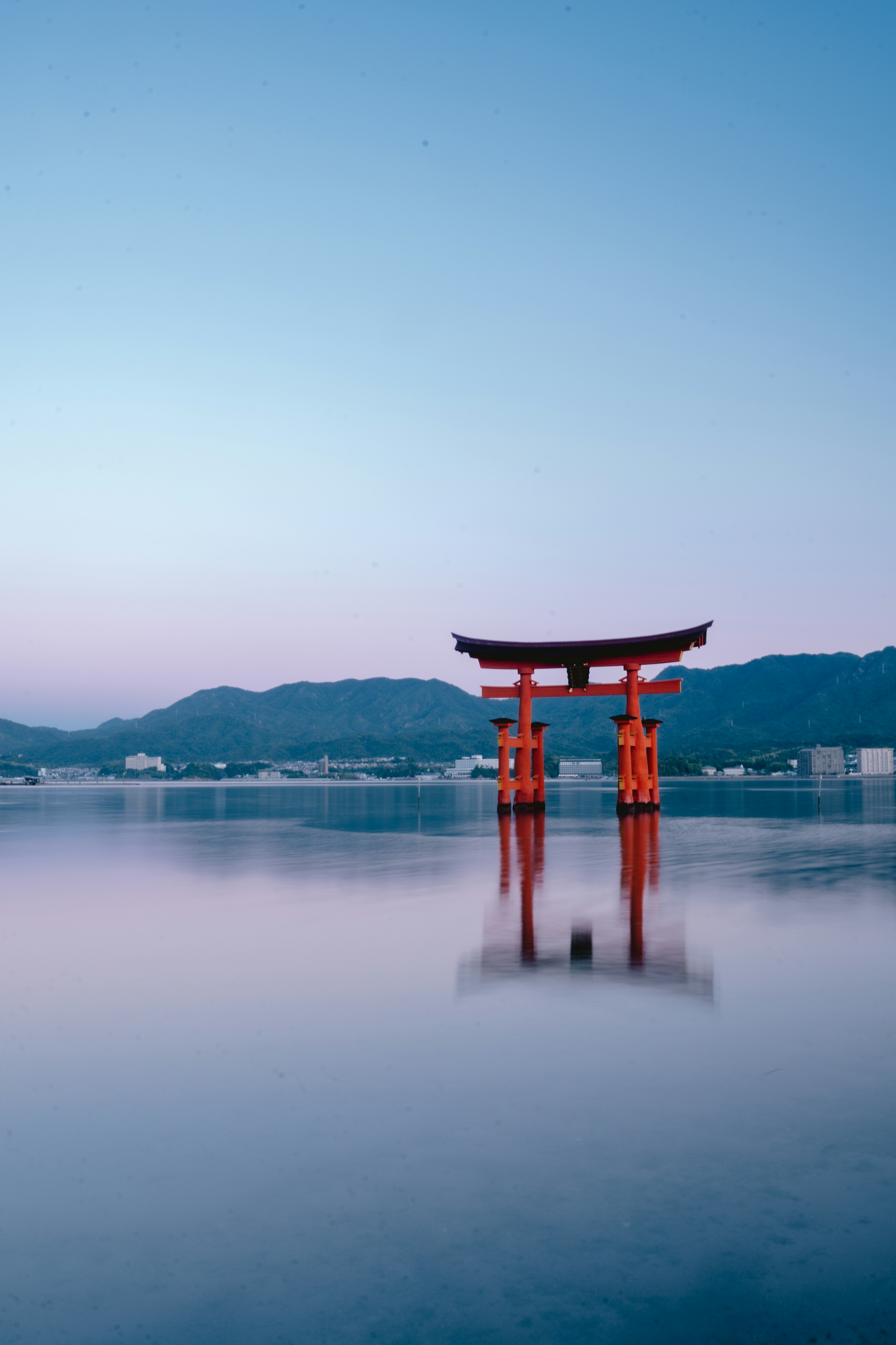 Bella vista di un torii rosso che si erge in un lago calmo