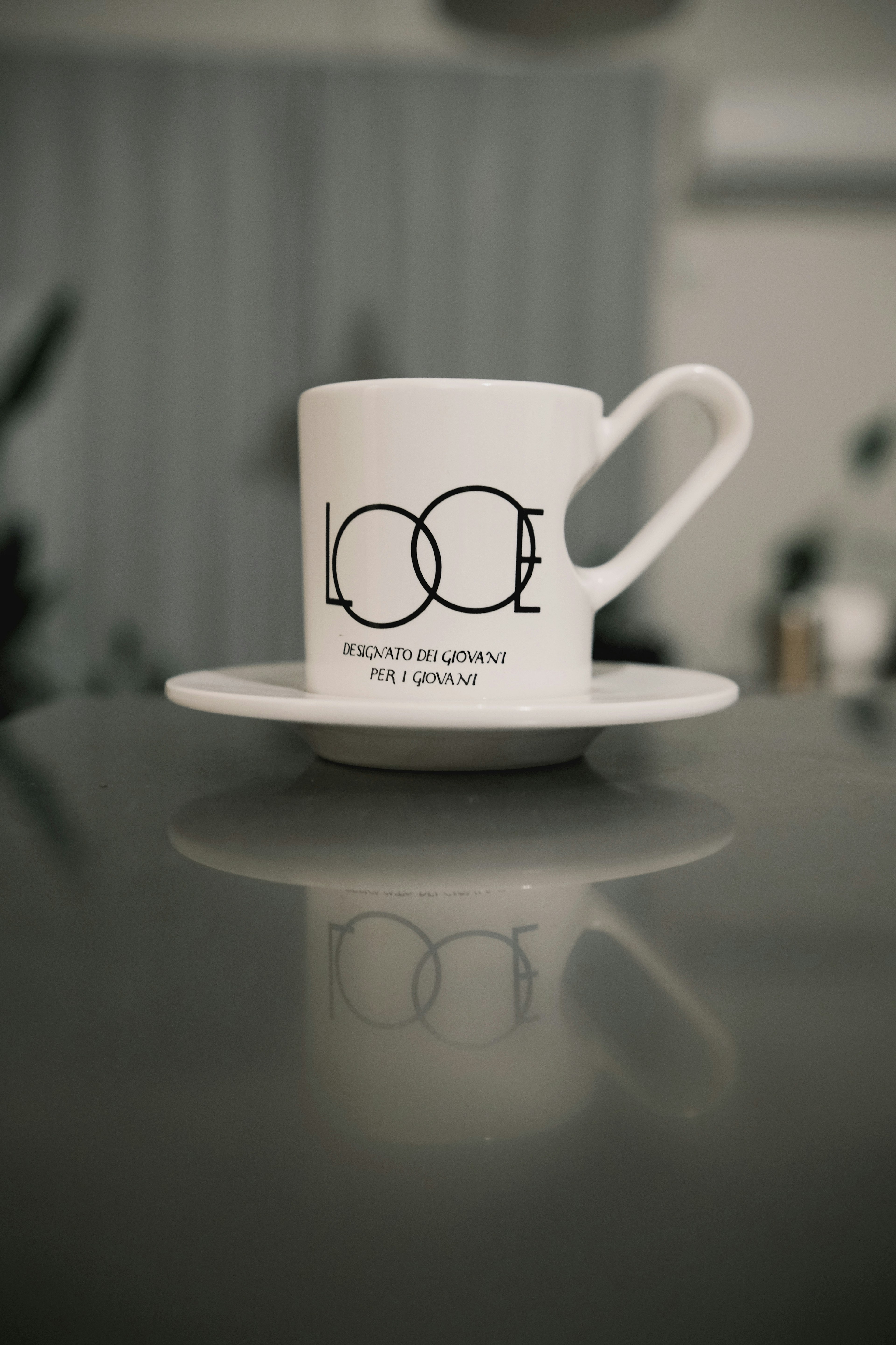 Una taza de café blanca y un platillo con un diseño simple