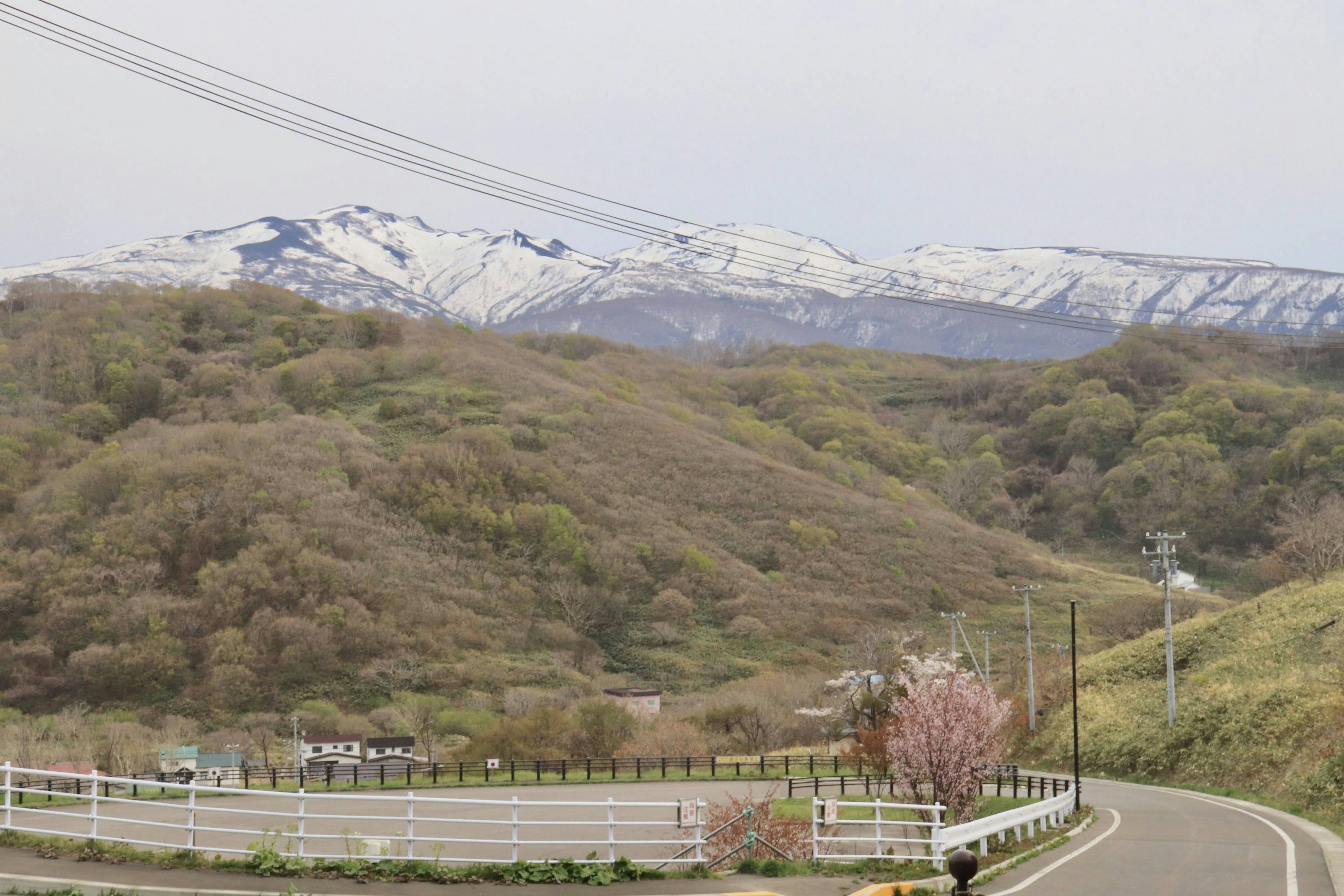 Scenic view of snow-capped mountains and green hills